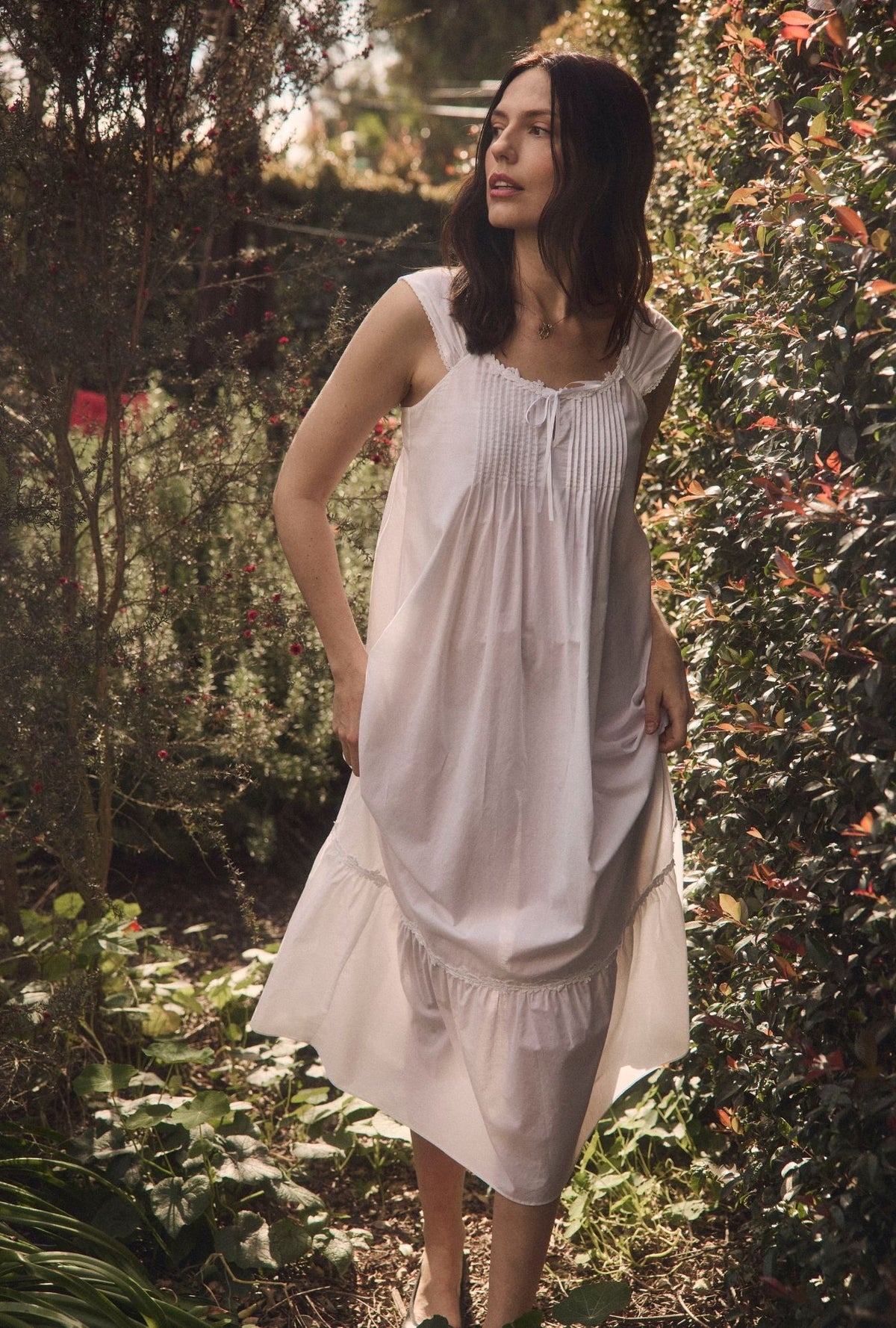 A lady wearing The "Taylor" Iconic White Cotton Lawn Ballet Nightgown in a garden