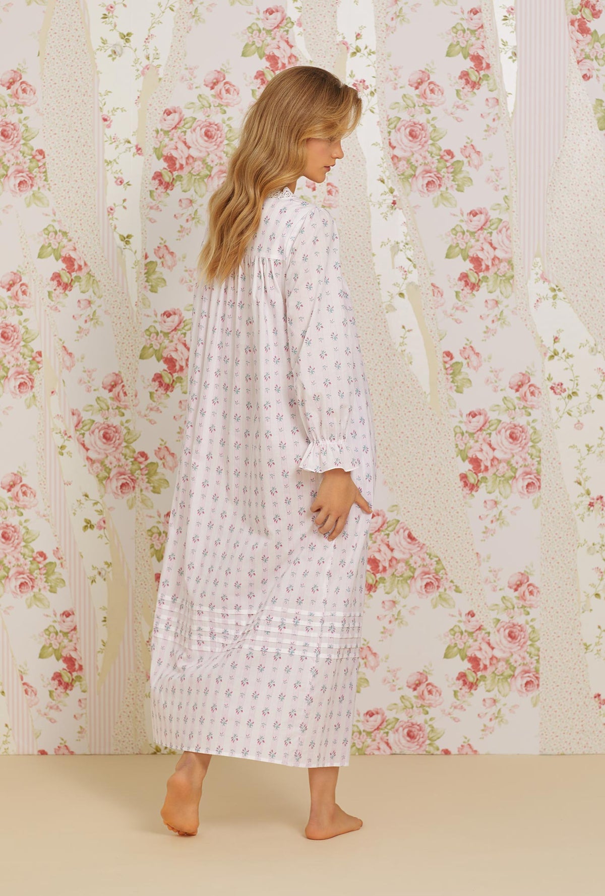 A lady wearing pink long sleeve long button front robe with sweetest floral stripe print.