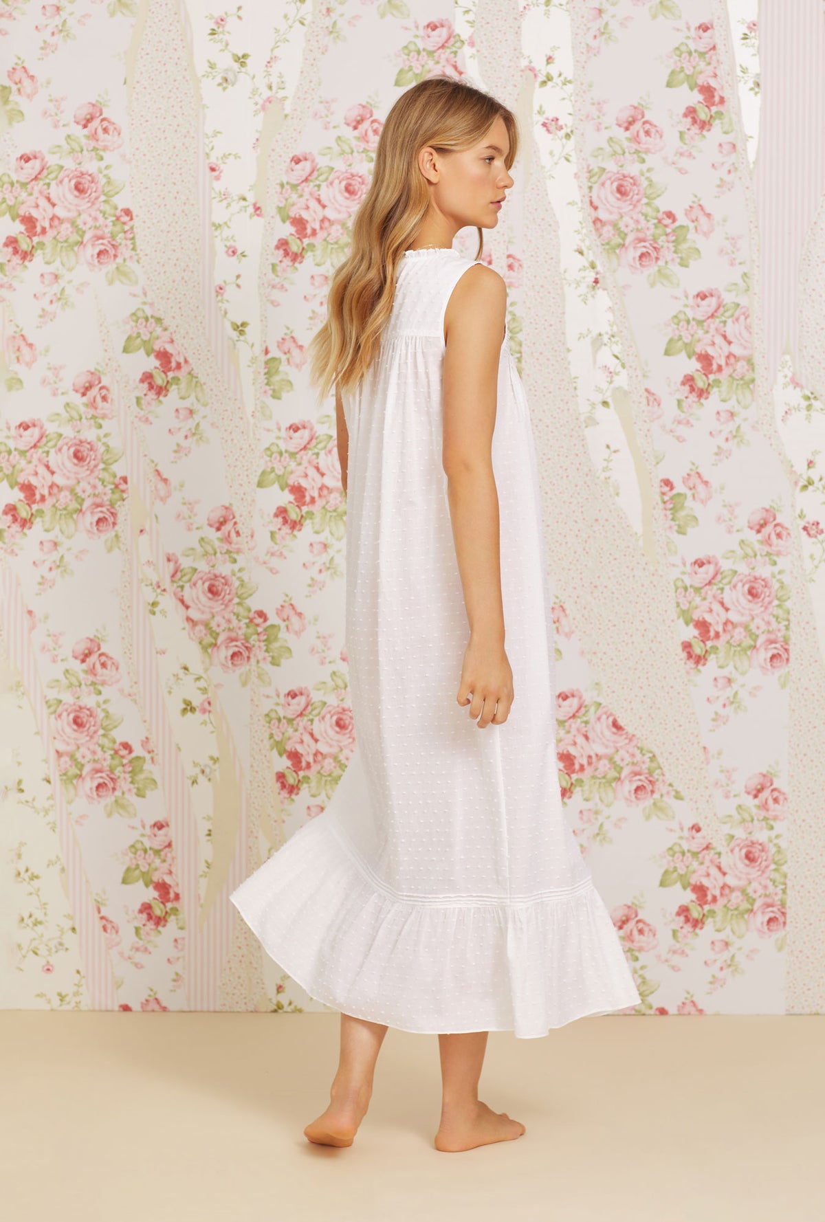 A lady wearing white sleeveless swiss dot eileen cotton nightgown.