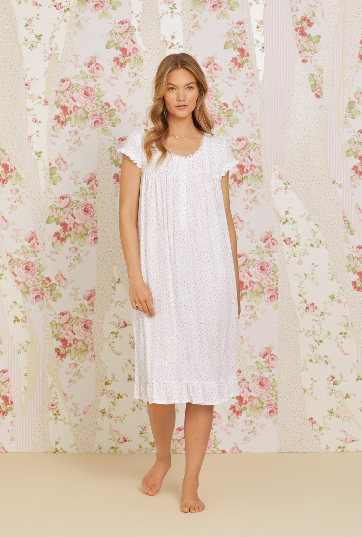 A lady wearing pink cap sleeve waltz knit nightgown with pointelle mini pink bud print.