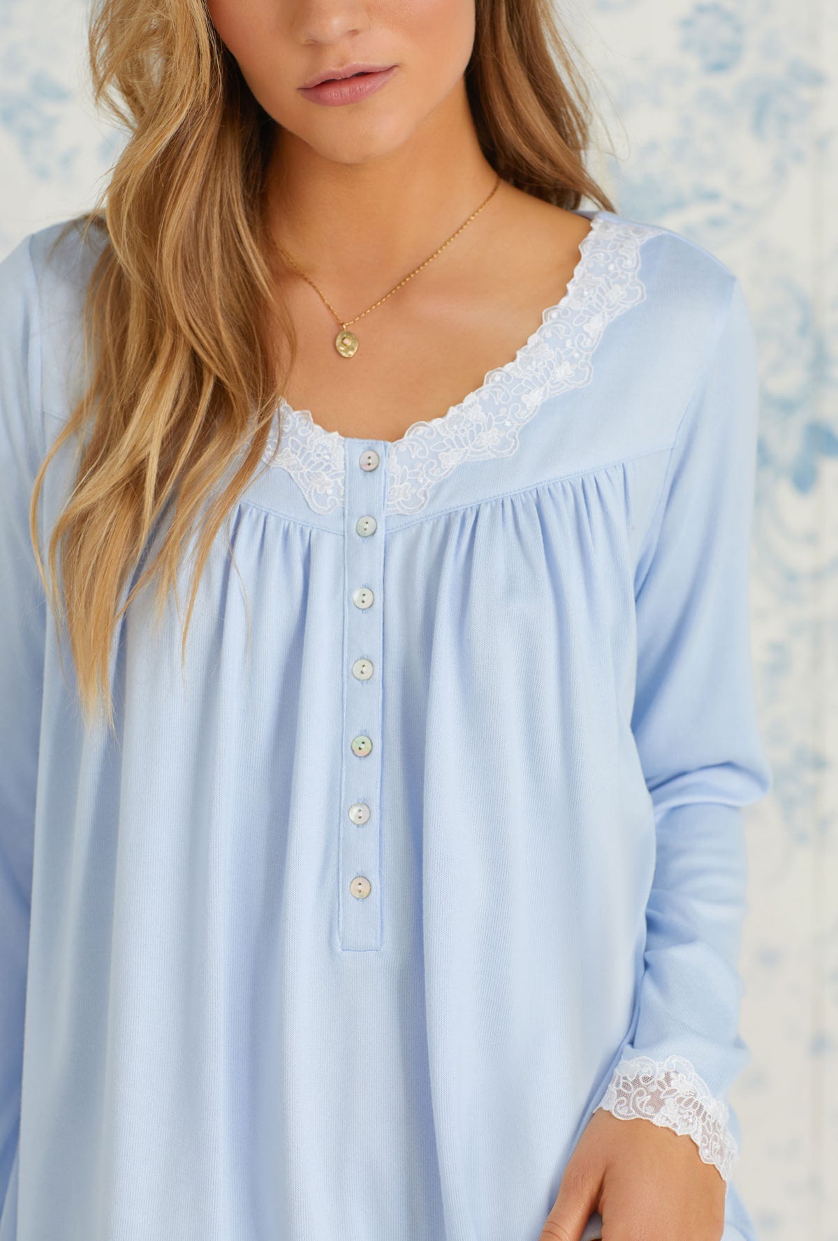 A lady wearing long sleeve blue cozy sweater knit short nightgown.