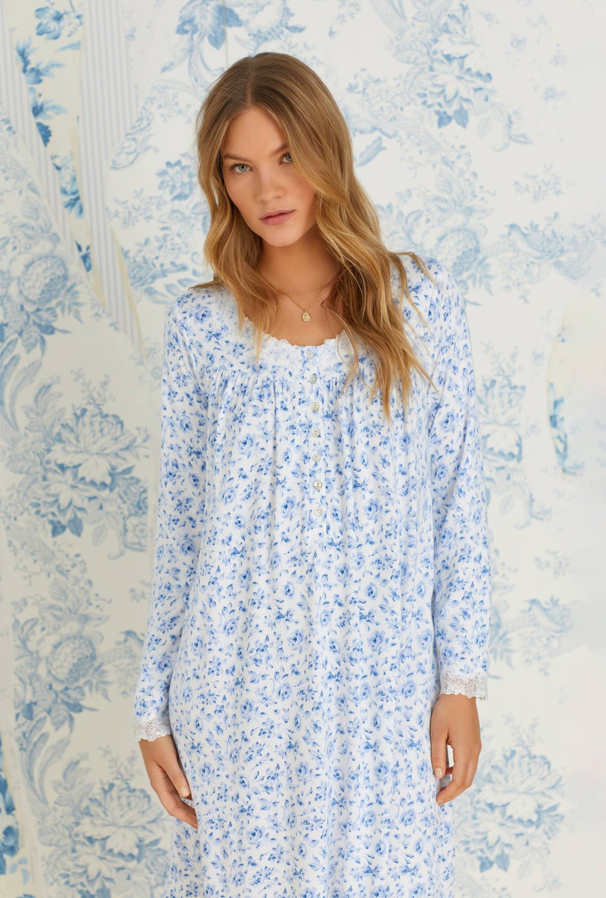 A lady wearing long sleeve classic blue roses cozy sweater knit short nightgown.