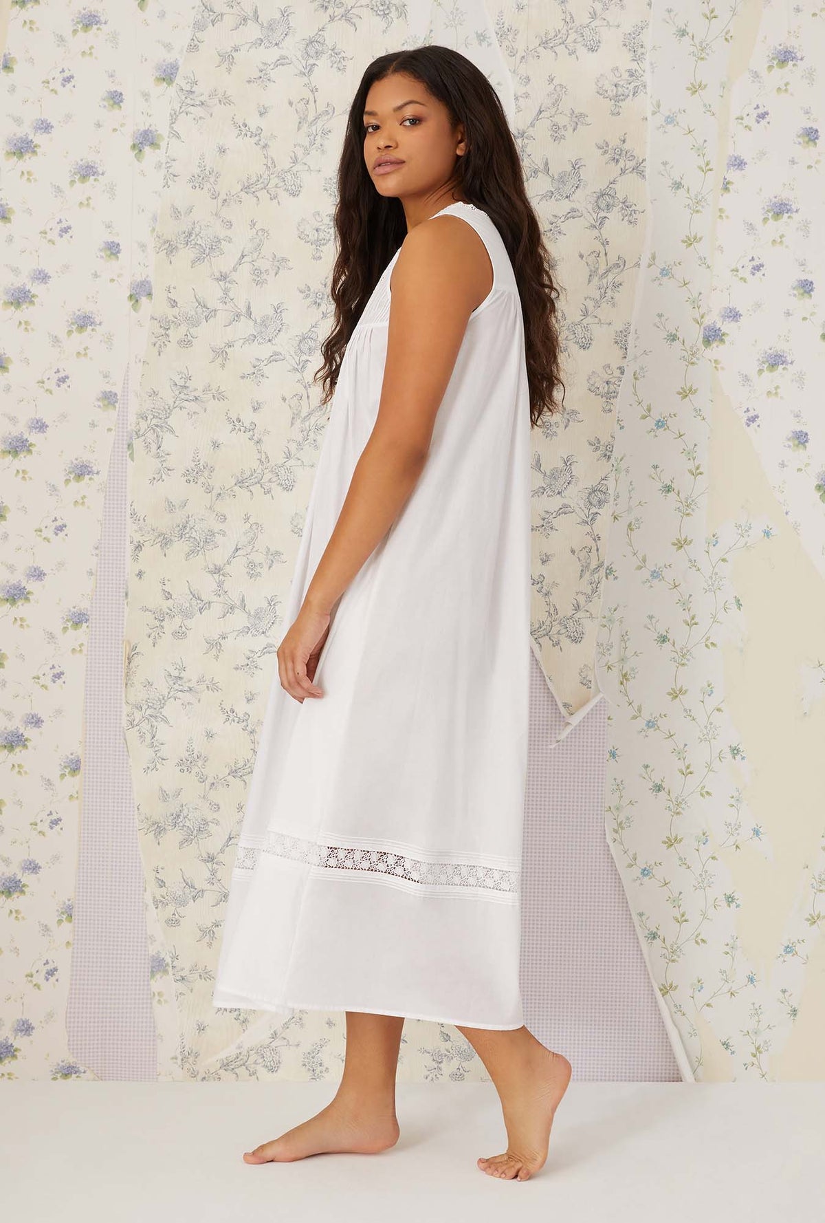 A lady wearing white sleeveless portofino ballet nightgown.