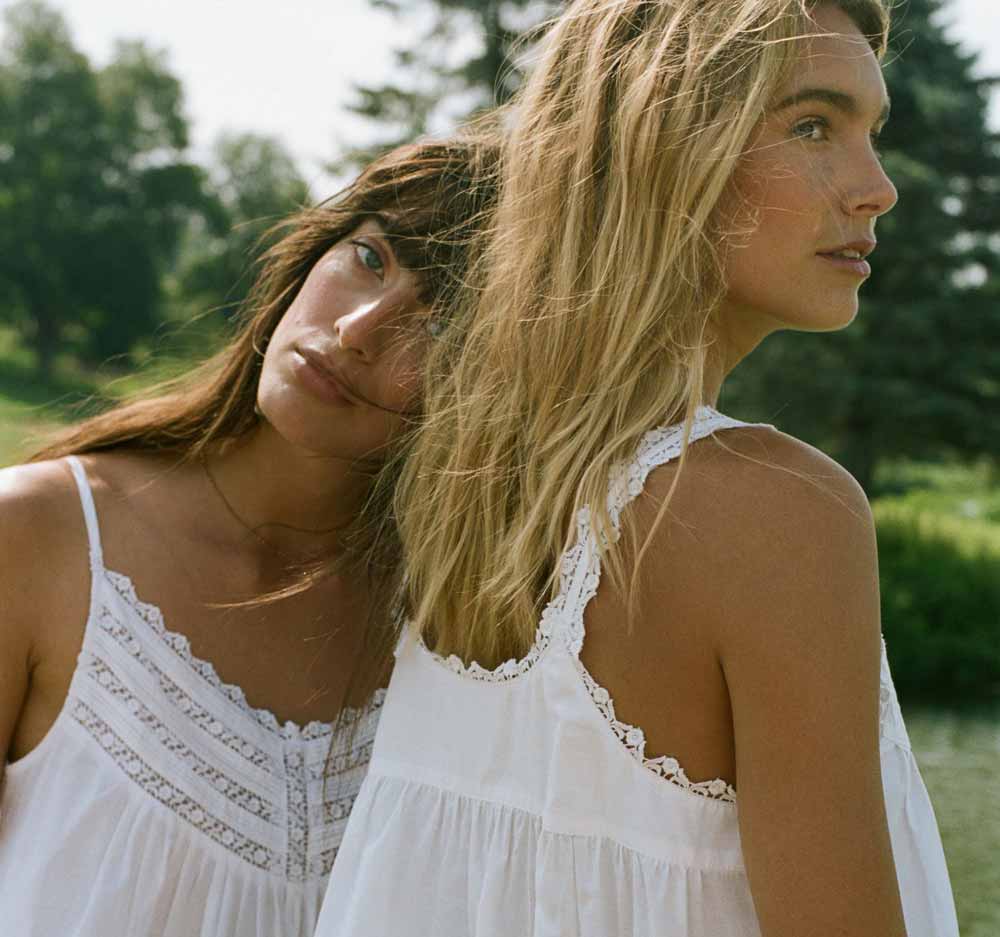 Two ladies wearing white gowns