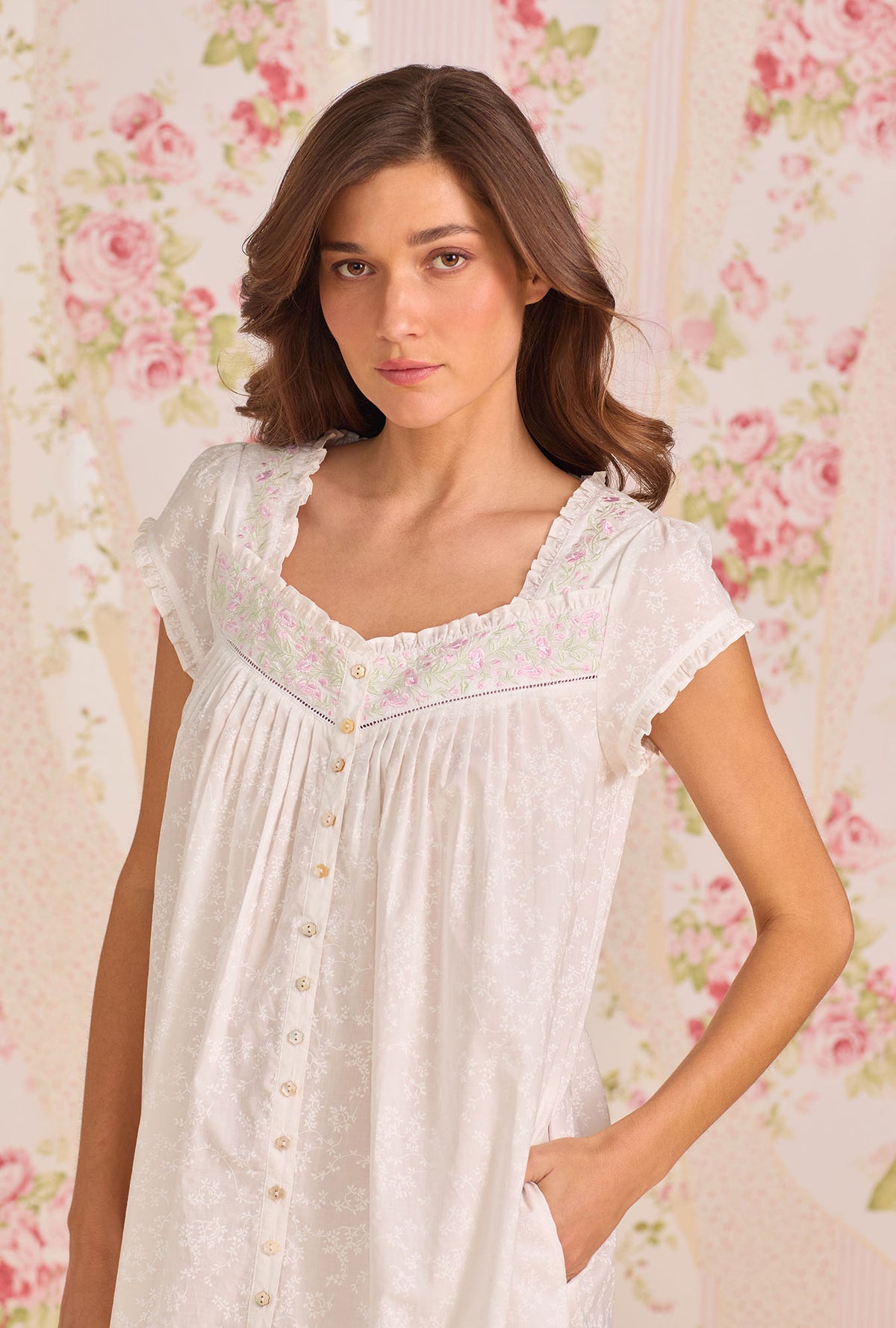 A Lady Wearing Shadow Floral Cotton Lawn Button Front Robe facing front in a half close up shot with one hand placing inside her pocket