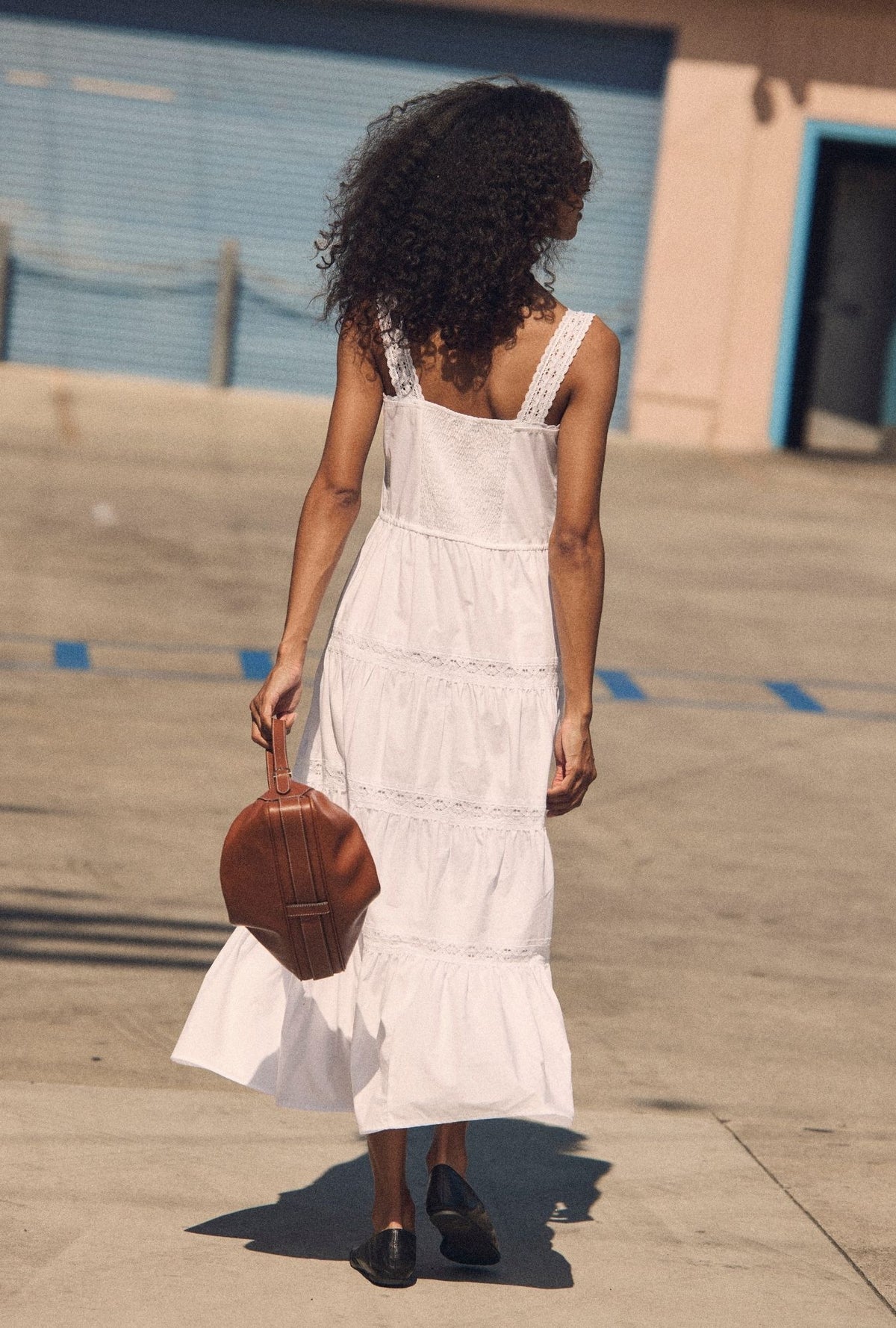 A lady wearing The "Elise" Soft White Cotton Maxi Dress back view