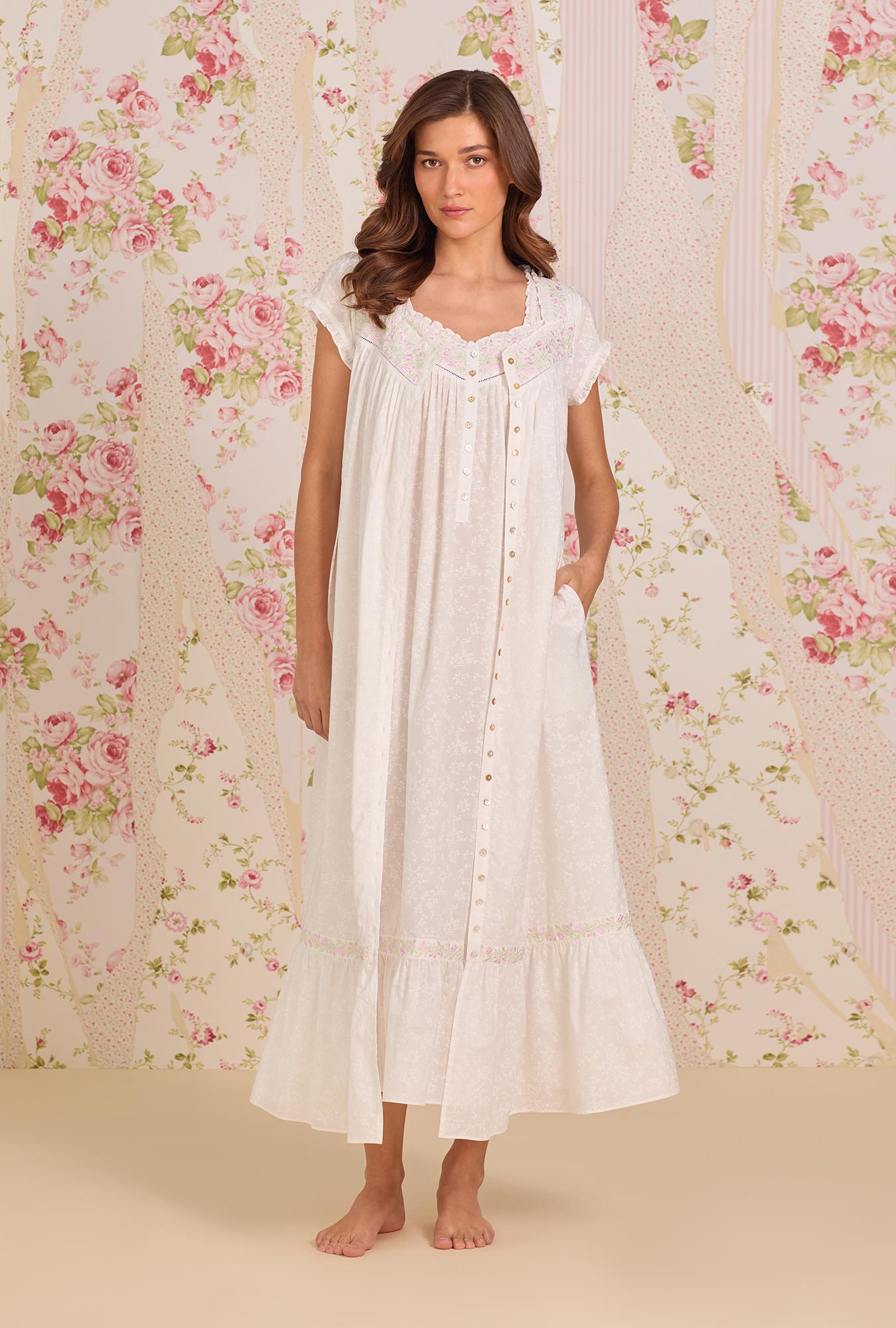 A Lady Wearing Shadow Floral Cotton Lawn Button Front Robe facing front in a standing pose with one hand placing inside her pocket
