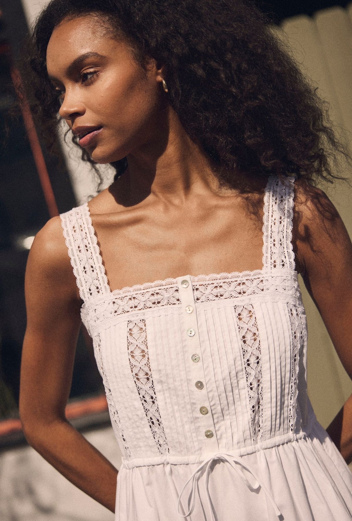 A lady wearing The "Elise" Soft White Cotton Maxi Dress  closer look looking side