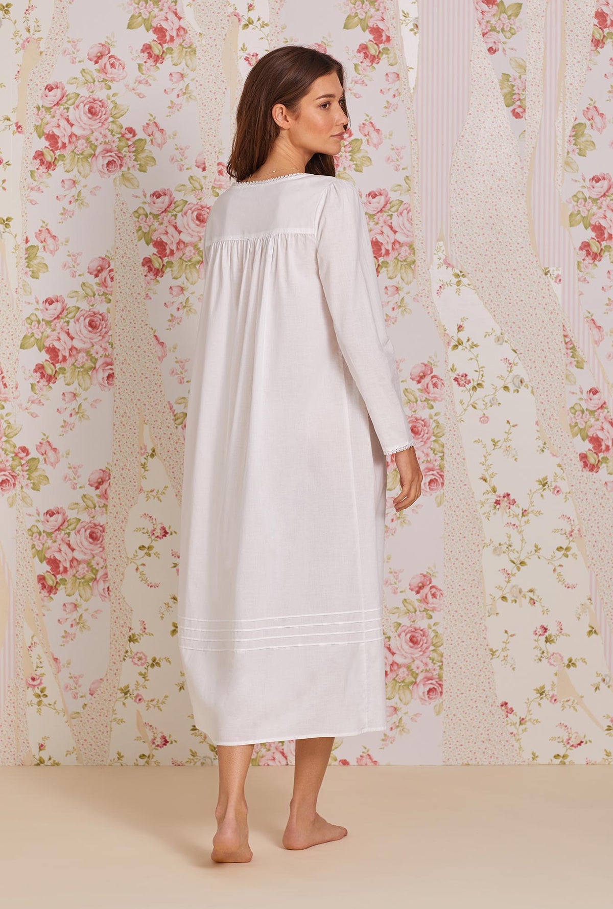 A lady wearing white long sleeve poetic nightgown.