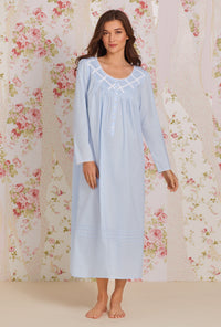 A lady wearing blue long sleeve poetic nightgown.