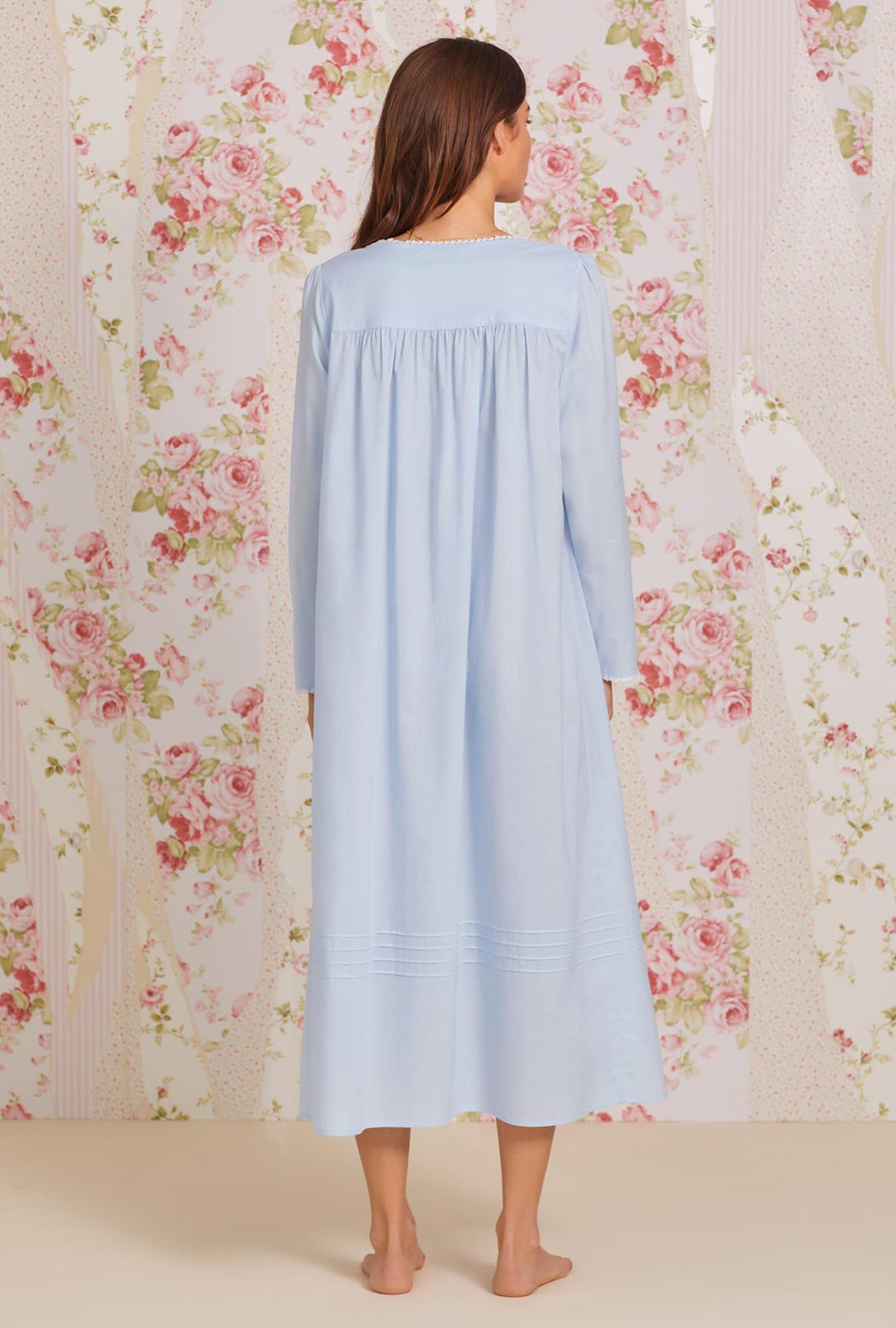 A lady wearing blue long sleeve poetic nightgown.