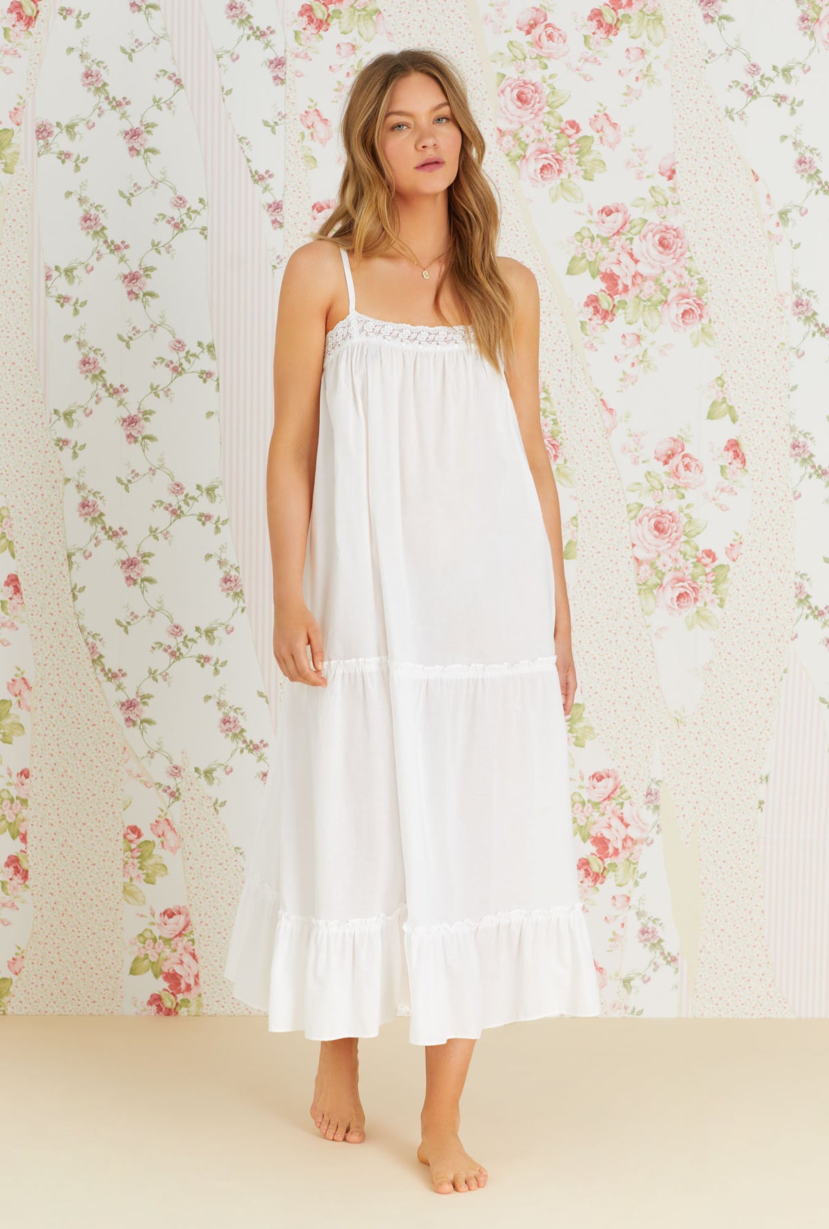 A lady wearing iconic white sleeveless cotton eleanora nightgown.