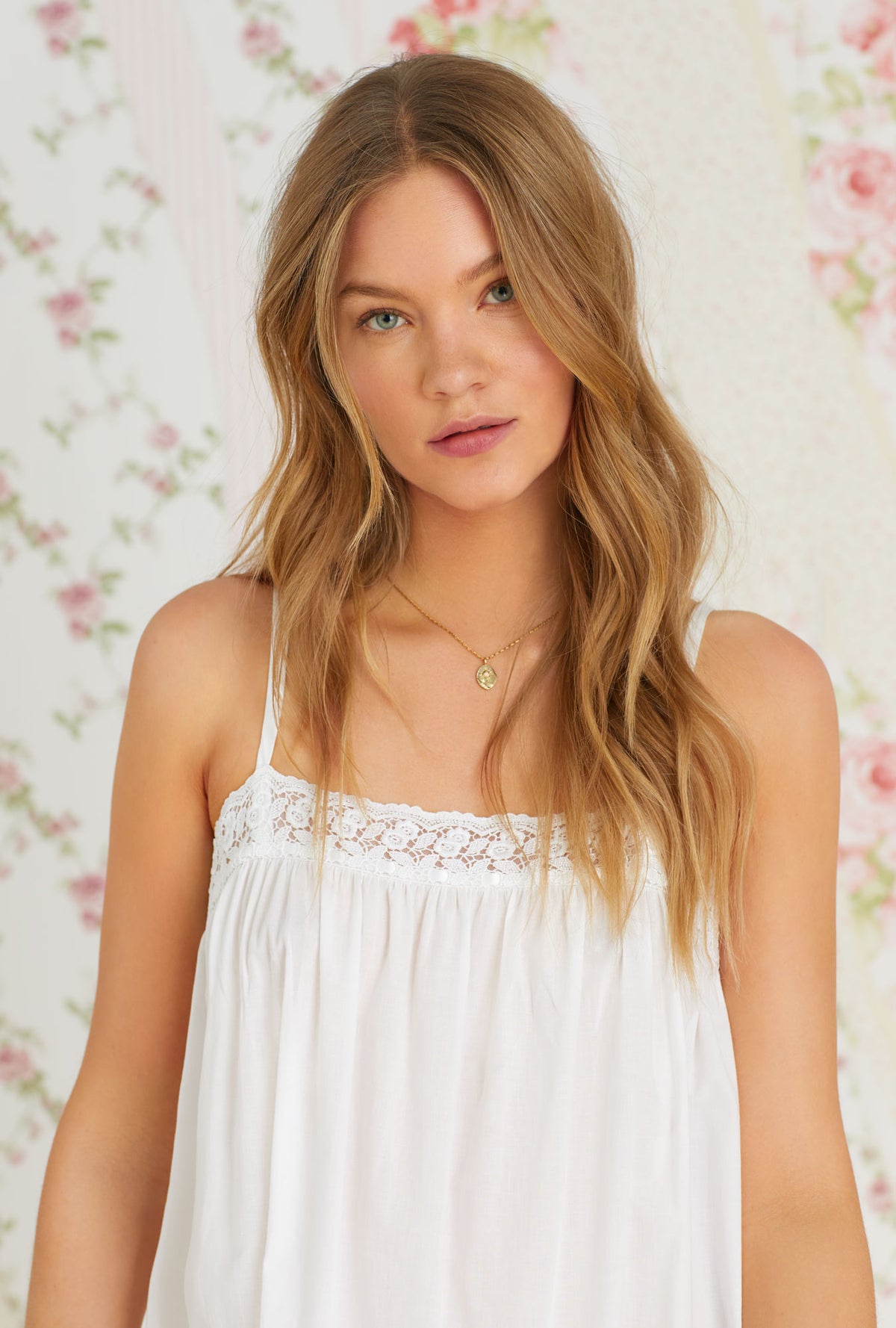 A lady wearing iconic white sleeveless cotton eleanora nightgown.