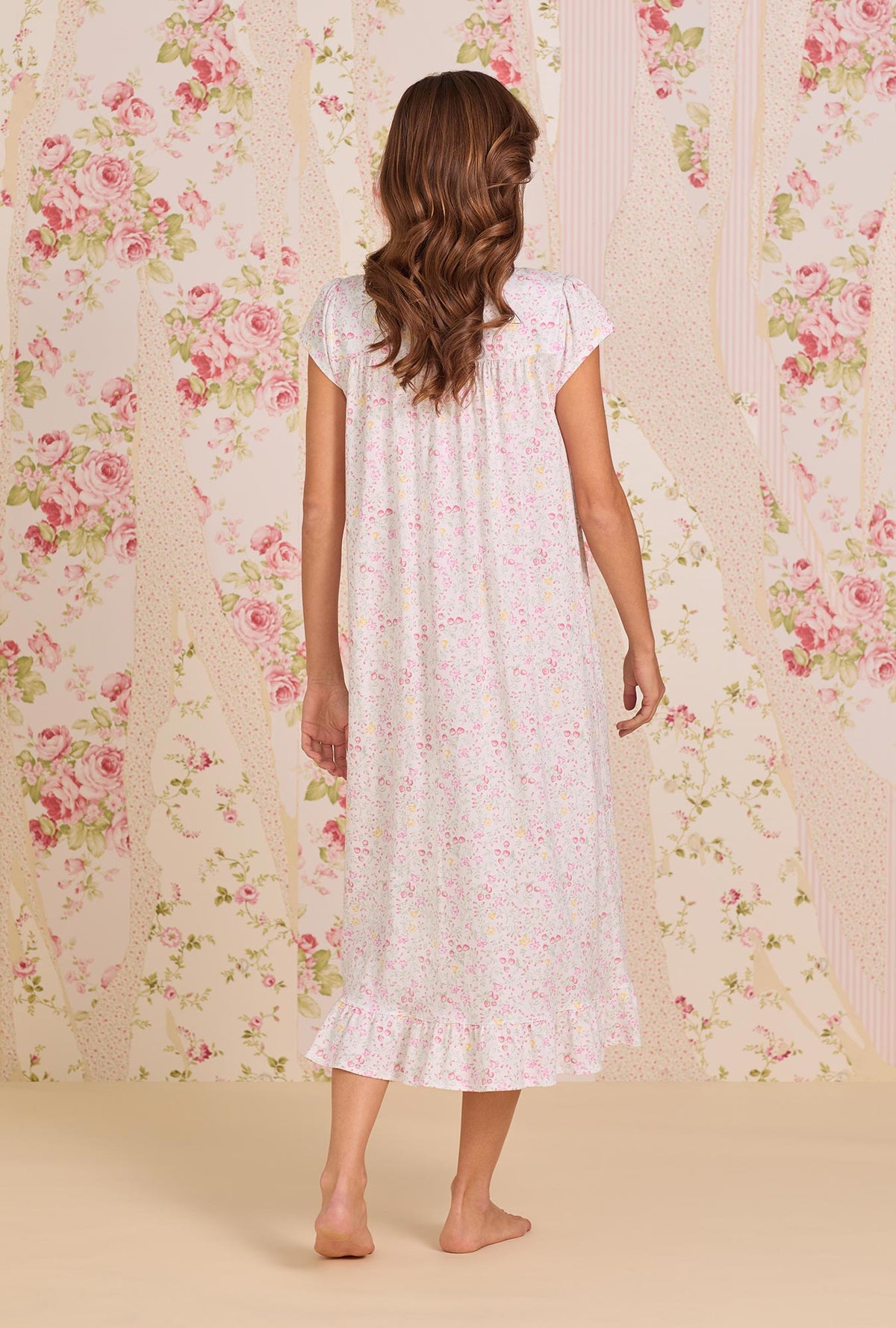 A Lady Wearing Strawberry Field Cotton Knit Cap Sleeve Ballet Nightgown facing back view of the dress with one leg placed slightly behind