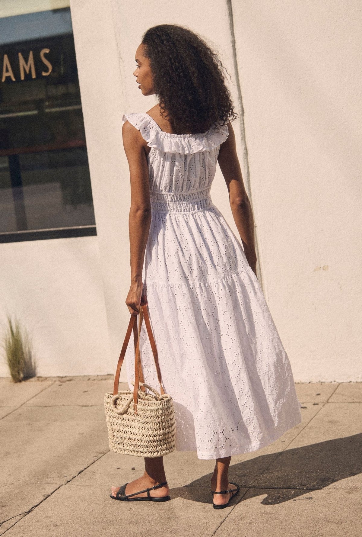 A lady wearing The "Isla" Soft White Cotton Maxi Dress back view