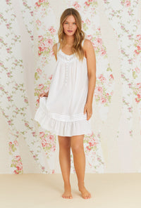 A lady wearing white sleeveless sheer stripe clip dot chemise with sandy white pattern.