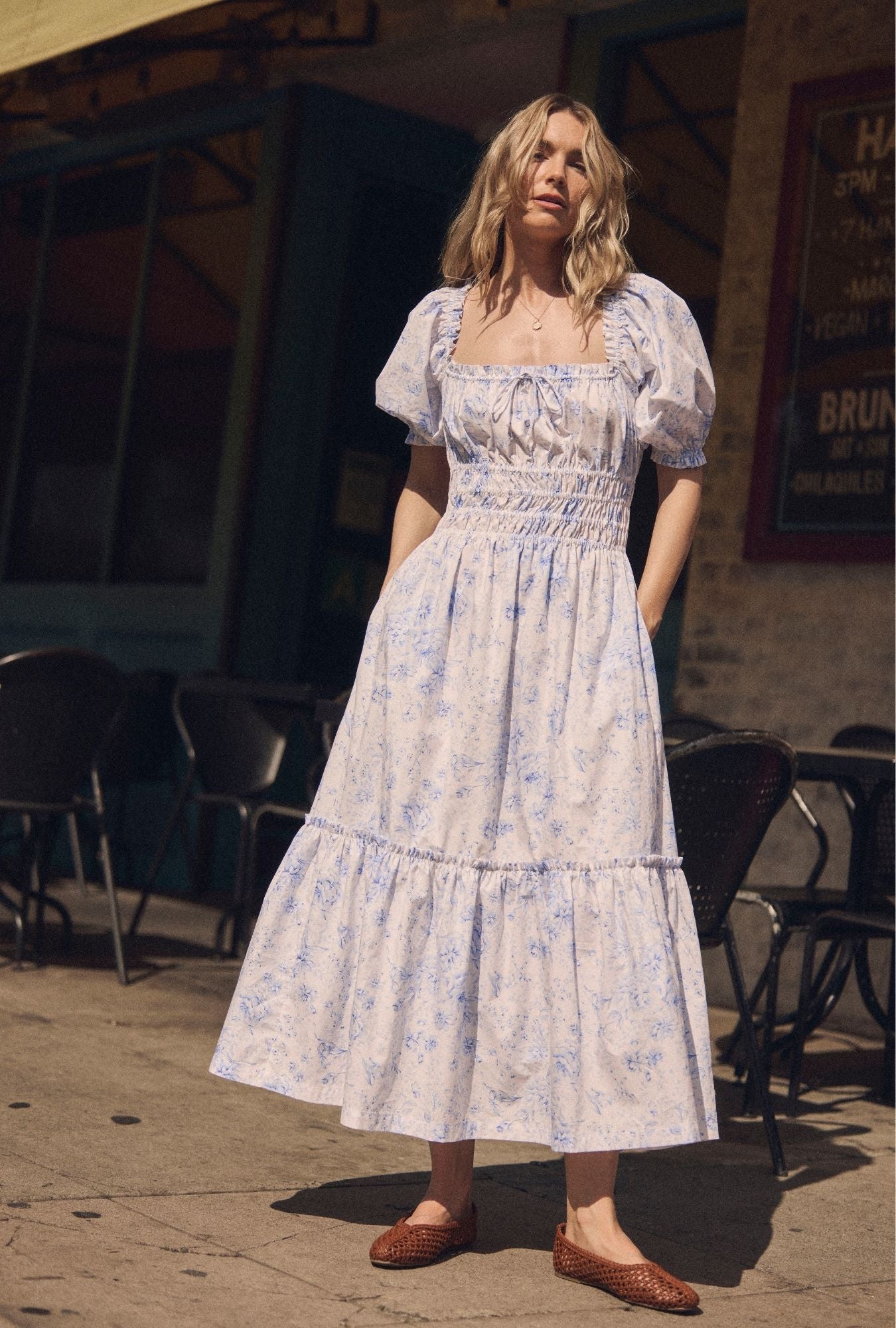 A lady wearing The "Marin" Coastal Toile Cotton Maxi Dress outside