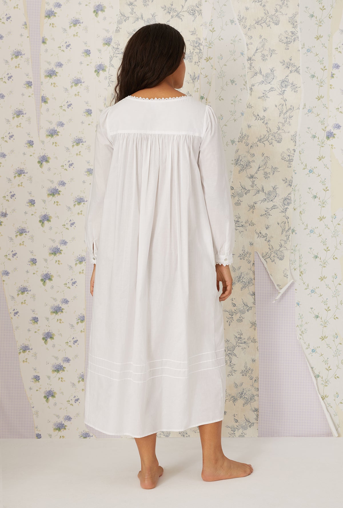 A lady wearing plus size White Heirloom Dream Long Sleeve Gown in a back view pose
