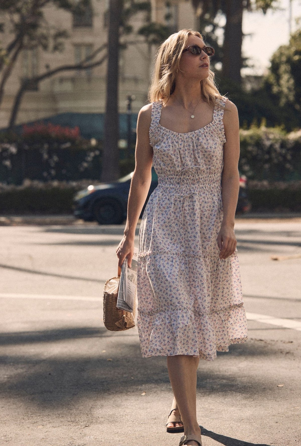 A lady wearing The "Nora" Buttercup Floral Cotton Midi Dress looking up waking