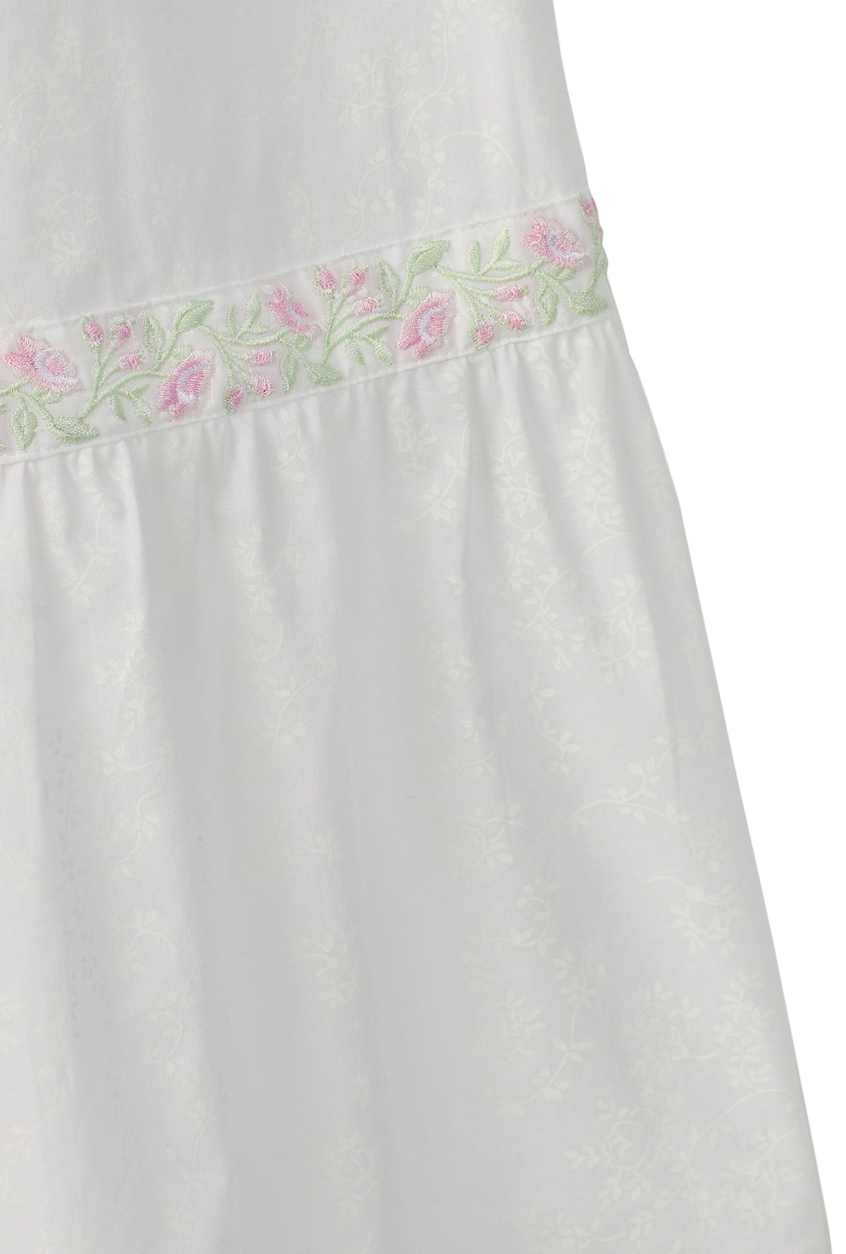 A lady wearing white sleeveless eileen cotton nightgown with garden rose embroidered  pattern.