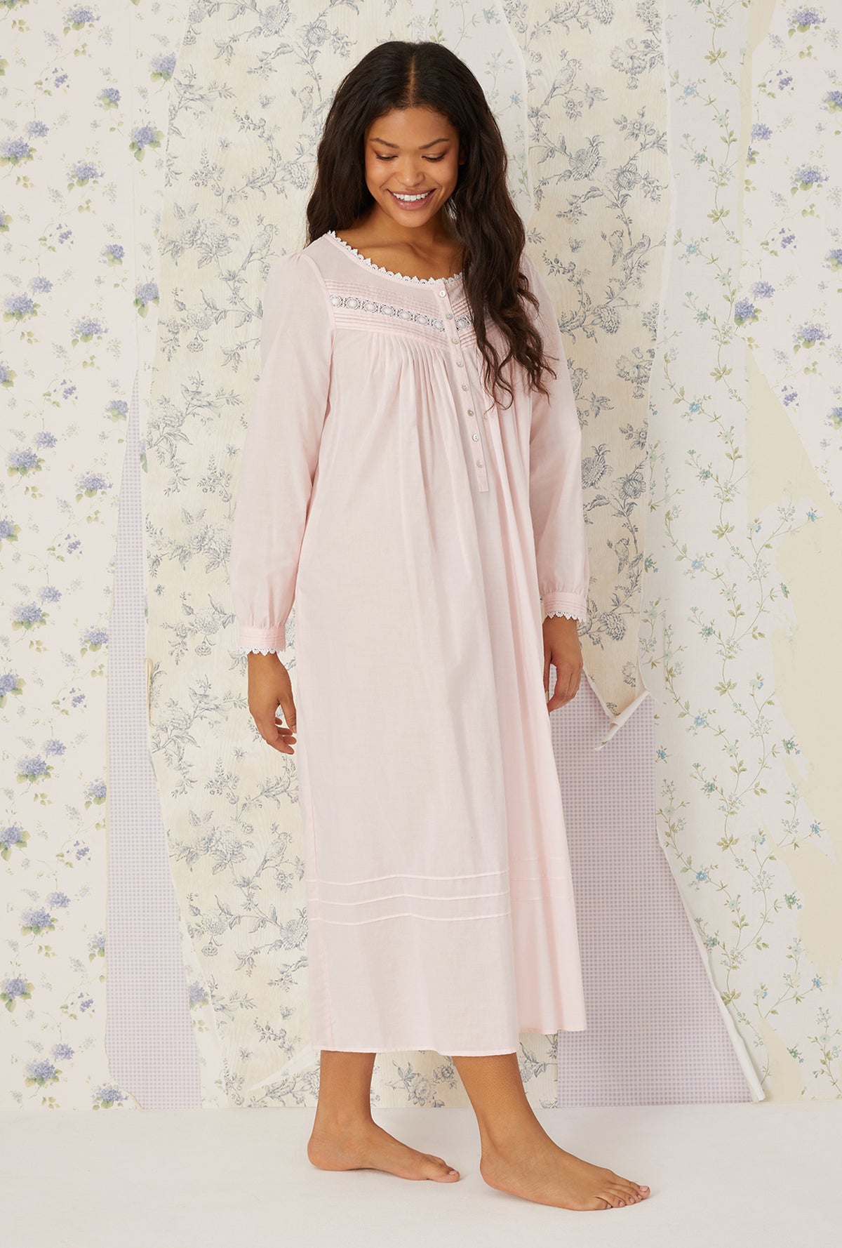 A lady wearing plus size blush Heirloom Dream Long Sleeve Gown in a side walking pose
