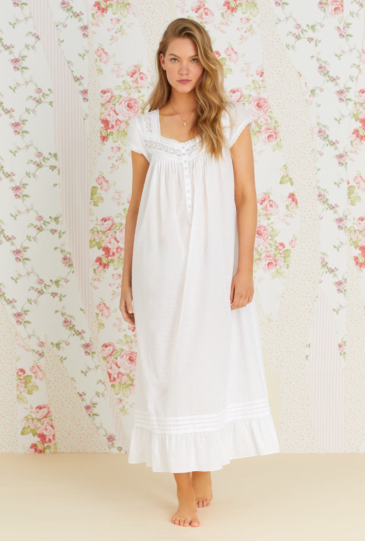 A lady wearing white cap sleeve sheer stripe clip dot nightgown with sandy white pattern.