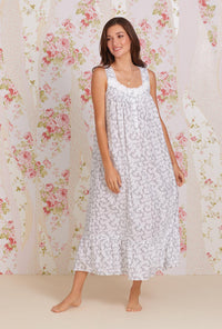 A lady wearing white sleeveless eileen cotton nightgown with grey fleur print.