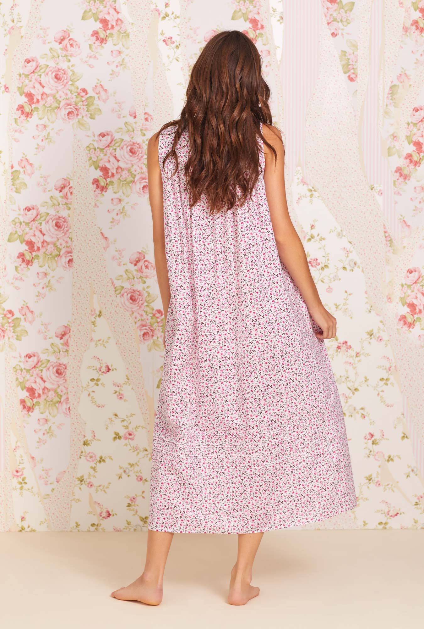 A lady wearing sleeveless eileen cotton lawn nightgown with rose jubilee print.