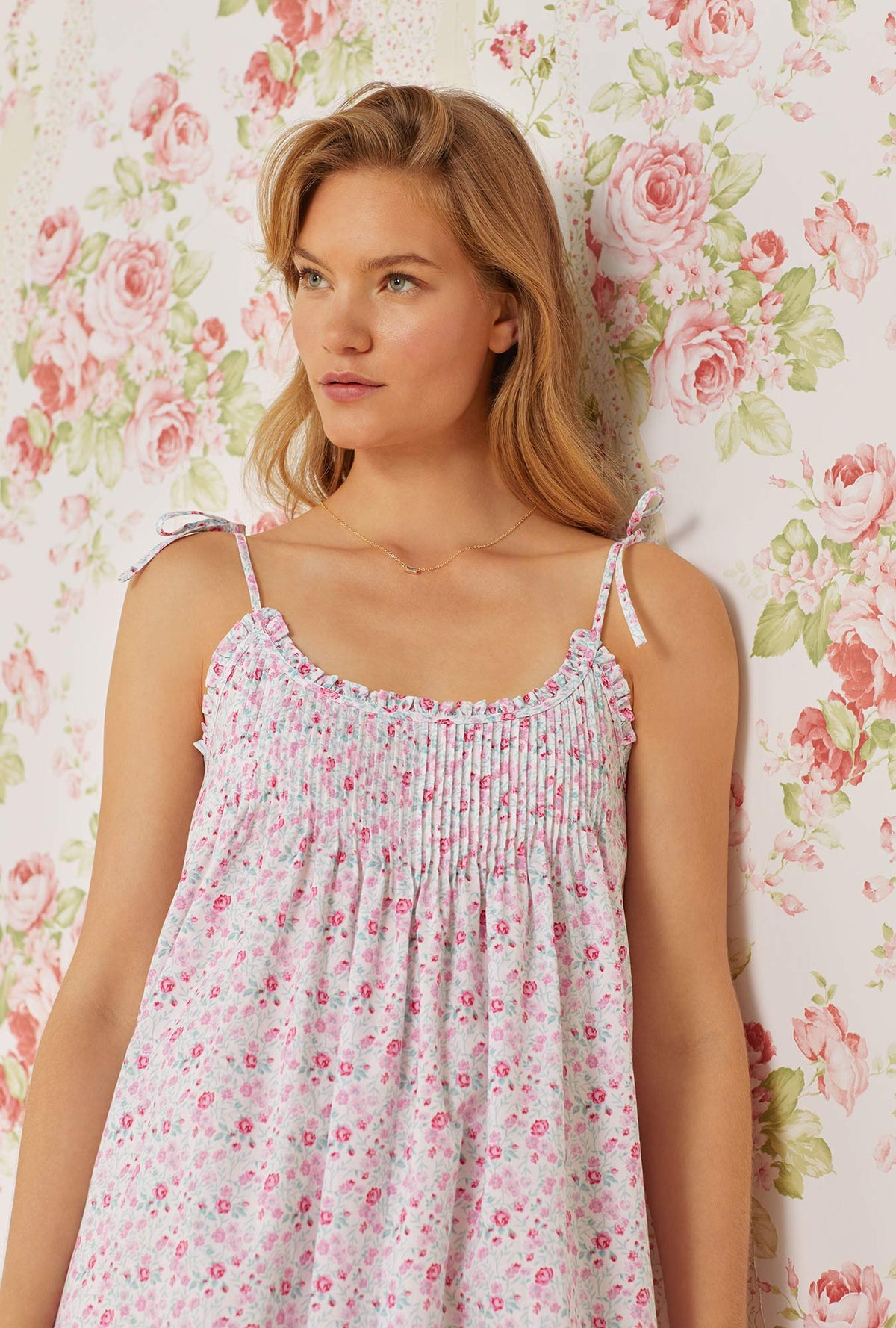 A lady wearing pink sleeveless erica cotton nightgown with secret garden print.