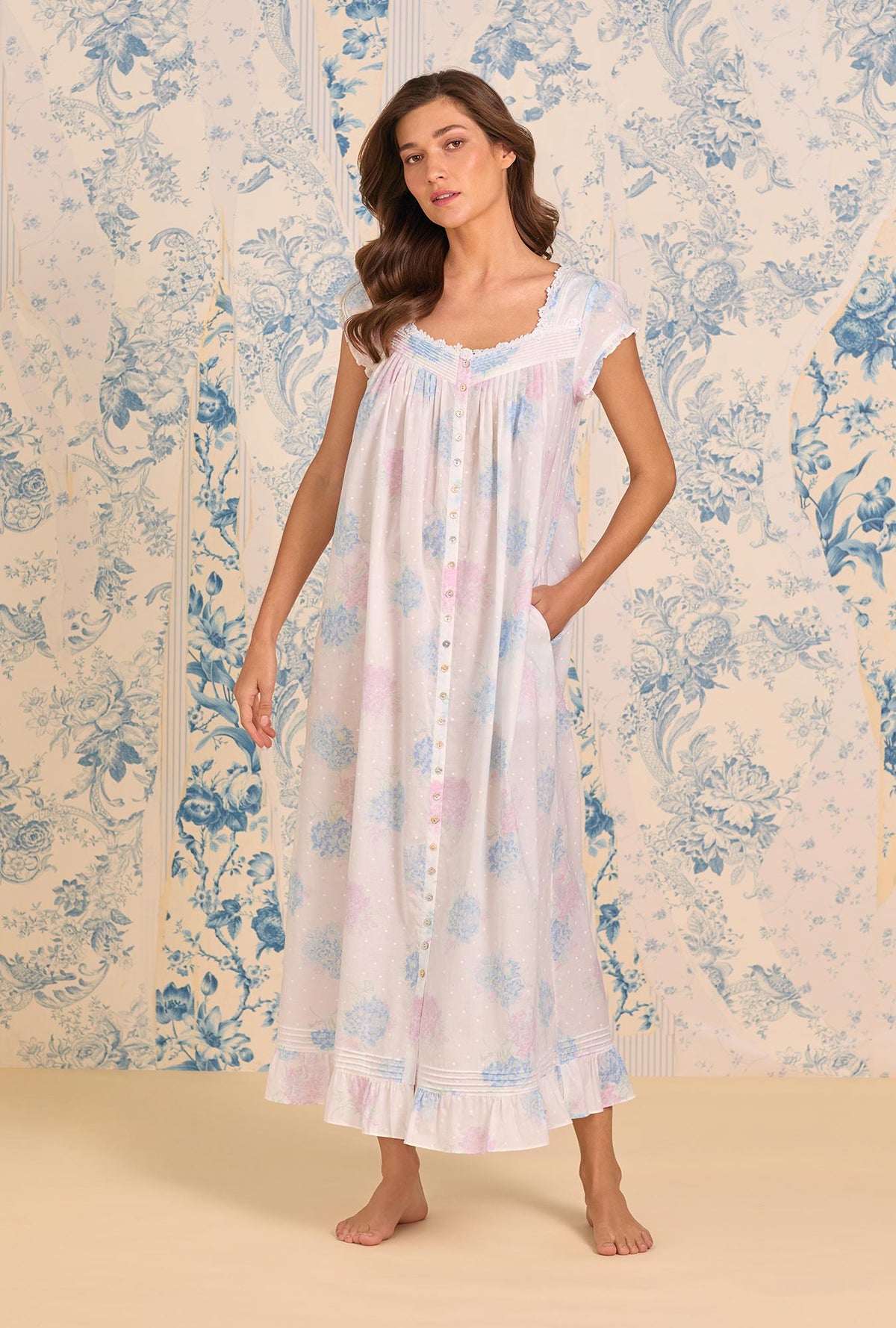 A lady wearing Hydrangea Blossom Cotton Lawn Button Front Robe one hand inside the pocket