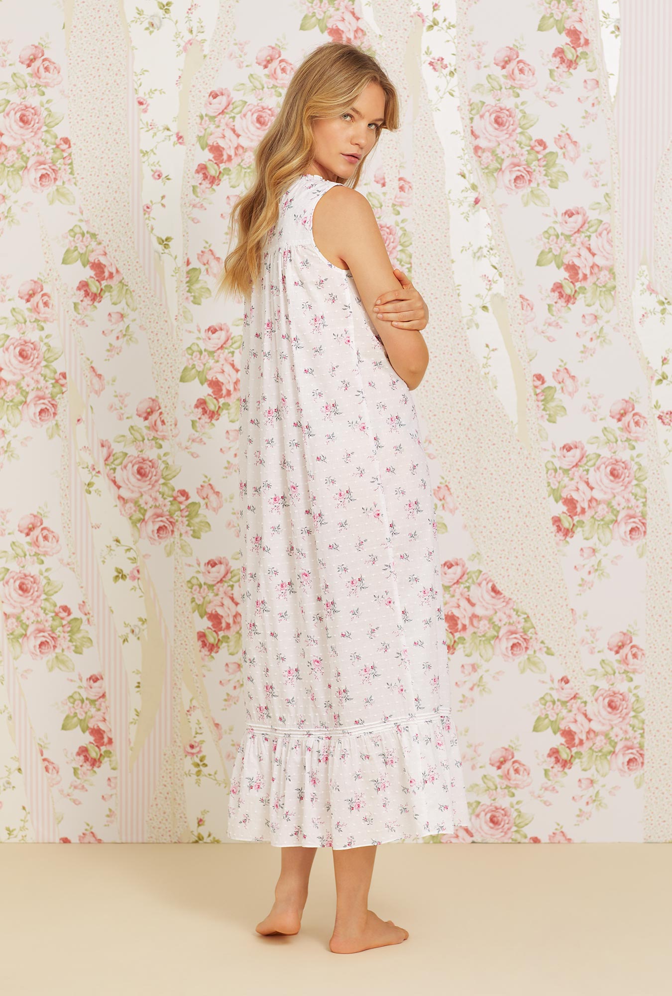 A lady wearing pink sleeveless eileen cotton nightgown with swiss dot jubilee floral print.