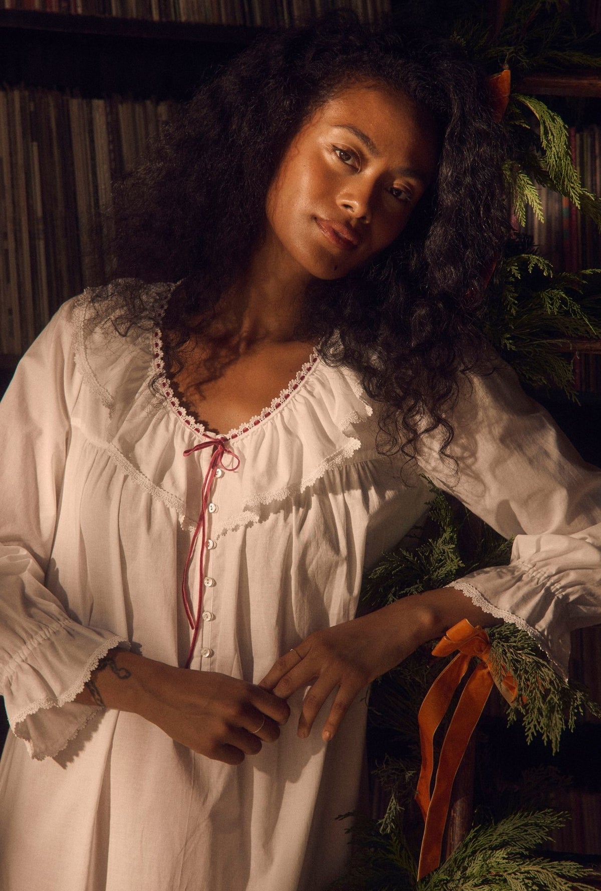 A lady wearing Clara Soft White 100% Cotton Woven Lawn Long Sleeve Nightdress, upper body leaning to her side.