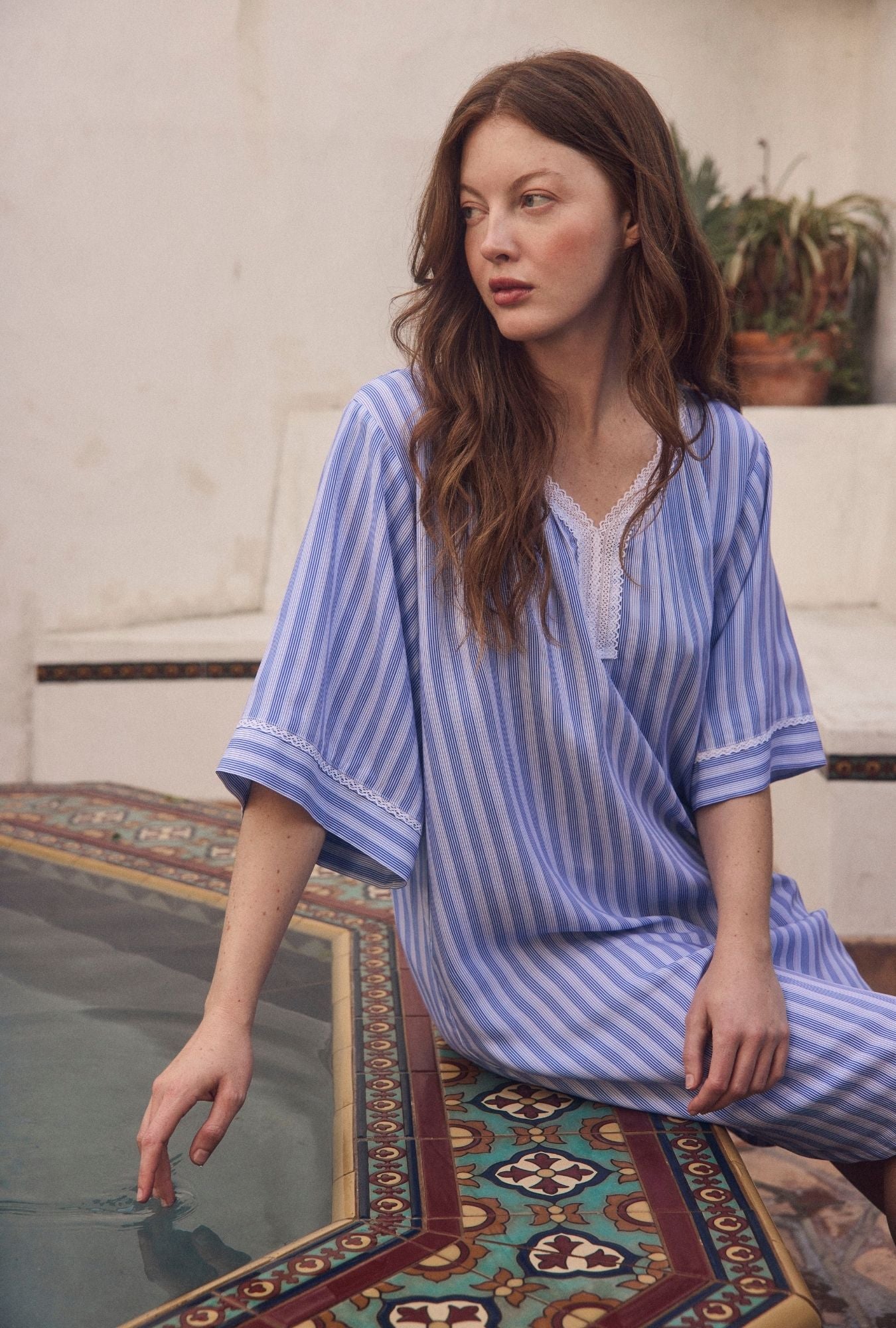 A lady weraring Harbour Stripe Ecovero™ Rayon Caftan sitting outside