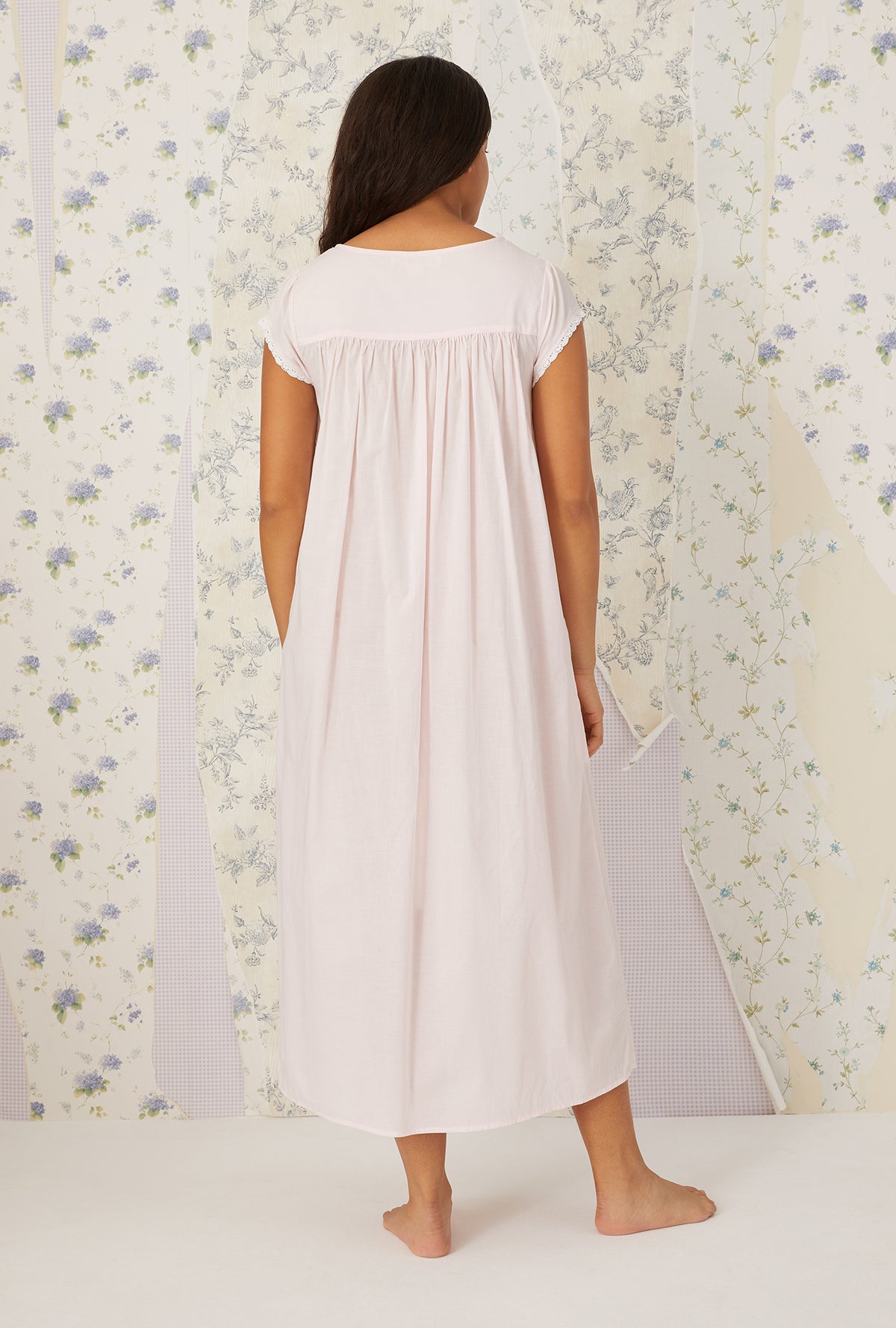 A lady wearing plus size white Florentine Lace Cap Sleeve Gown in a back view pose