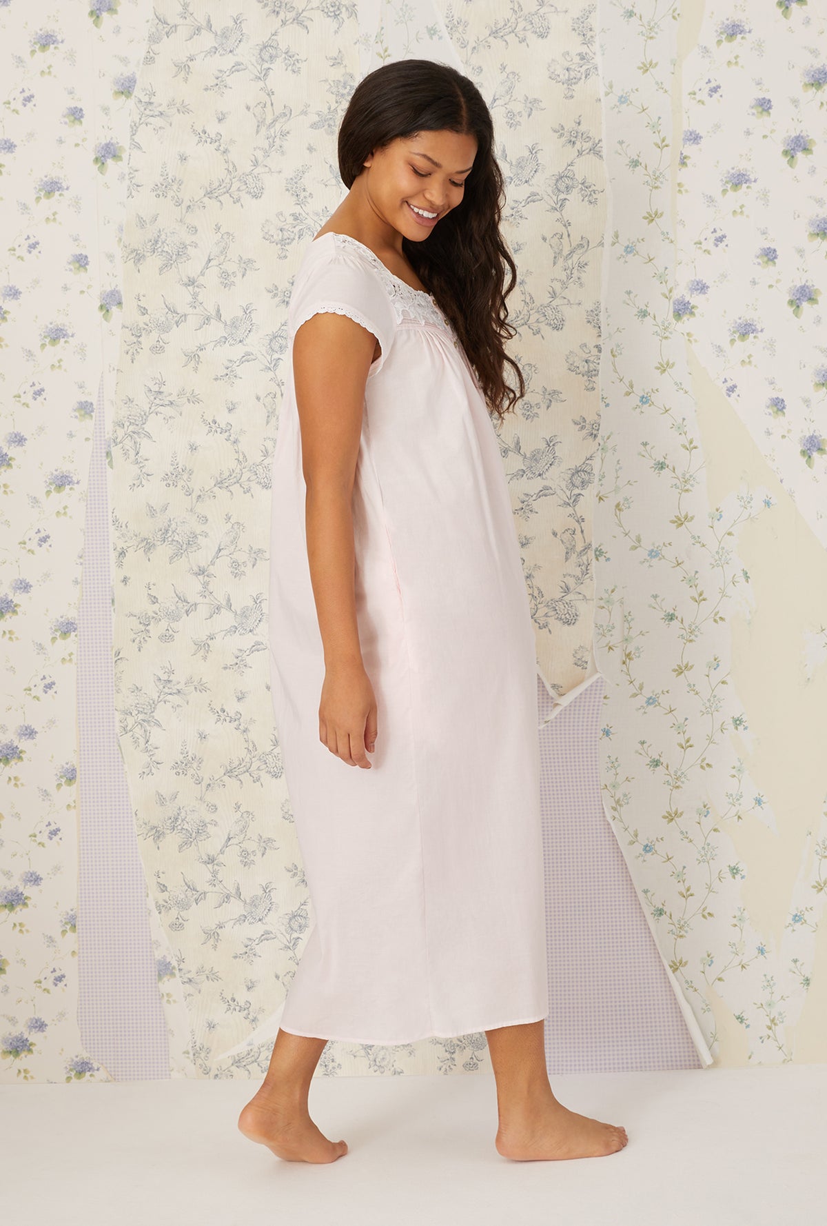 A lady wearing plus size white Florentine Lace Cap Sleeve Gown in a side pose with a smile