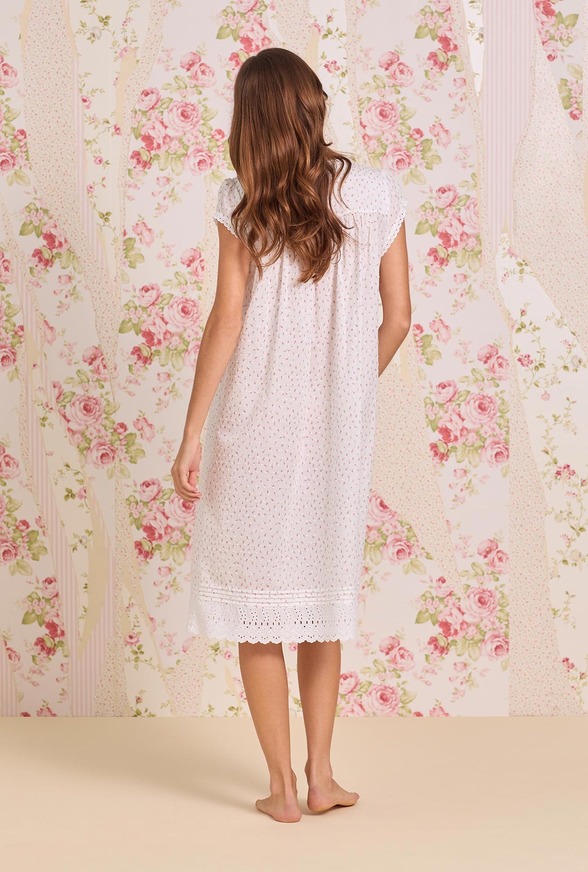 A lady wearing Rosebud Sprig Cotton Swiss Dot Cap Sleeve Waltz Nightgown back view