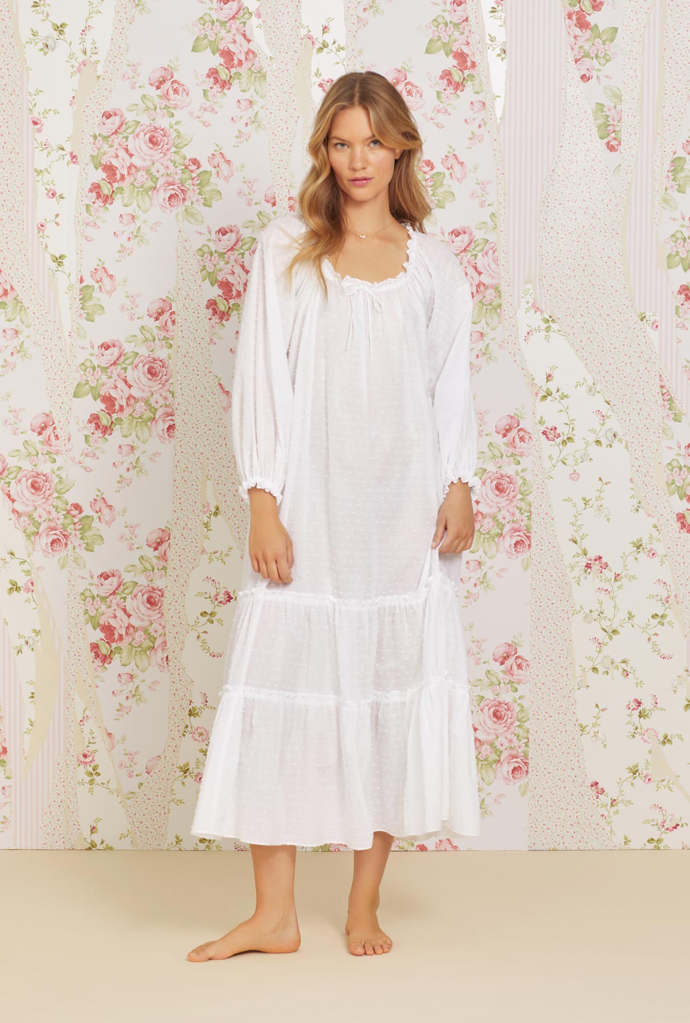 A lady wearing white long sleeve swiss dot bethany nightgown.