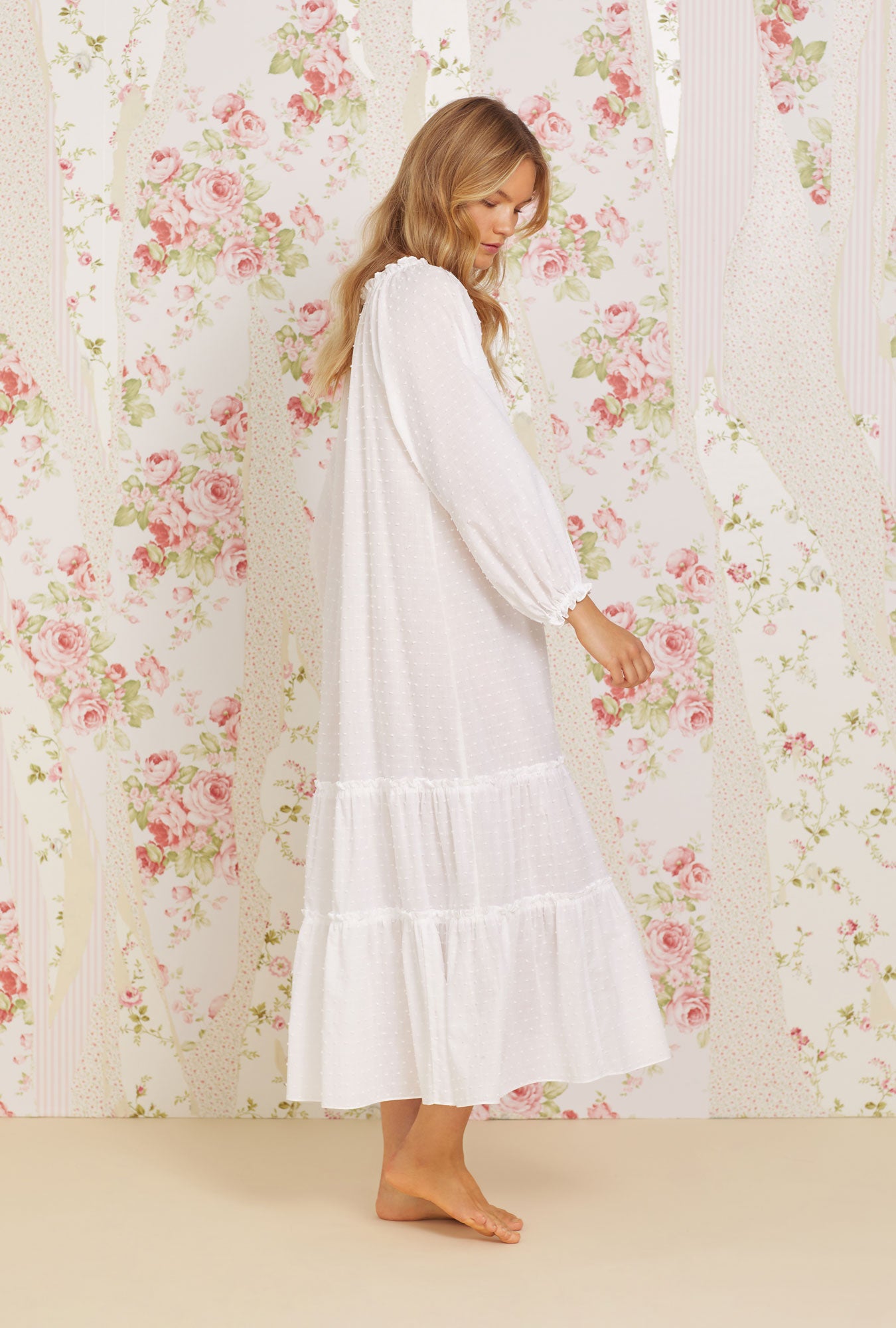 A lady wearing white long sleeve swiss dot bethany nightgown.
