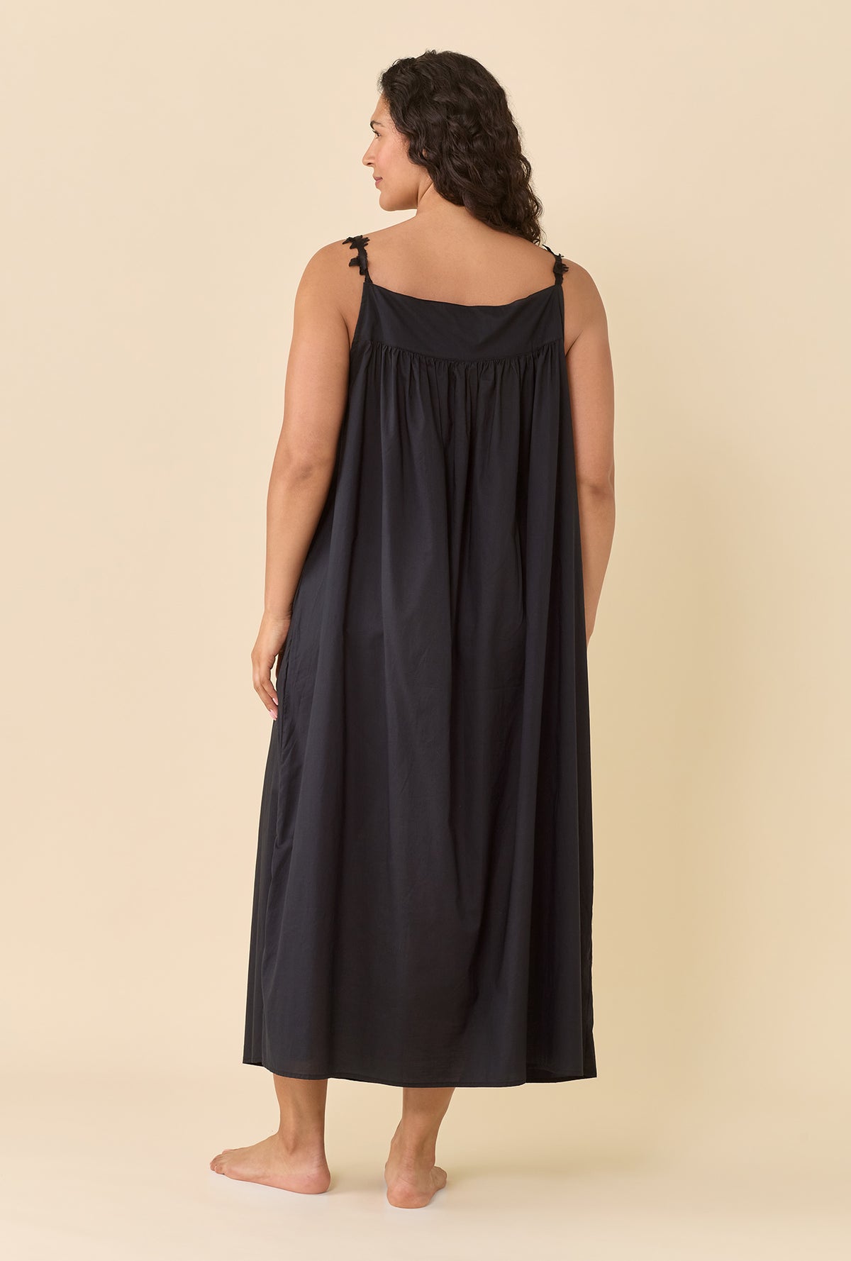 A lady wearing plus size black Florentine Lace Ballet Gown in a back view pose