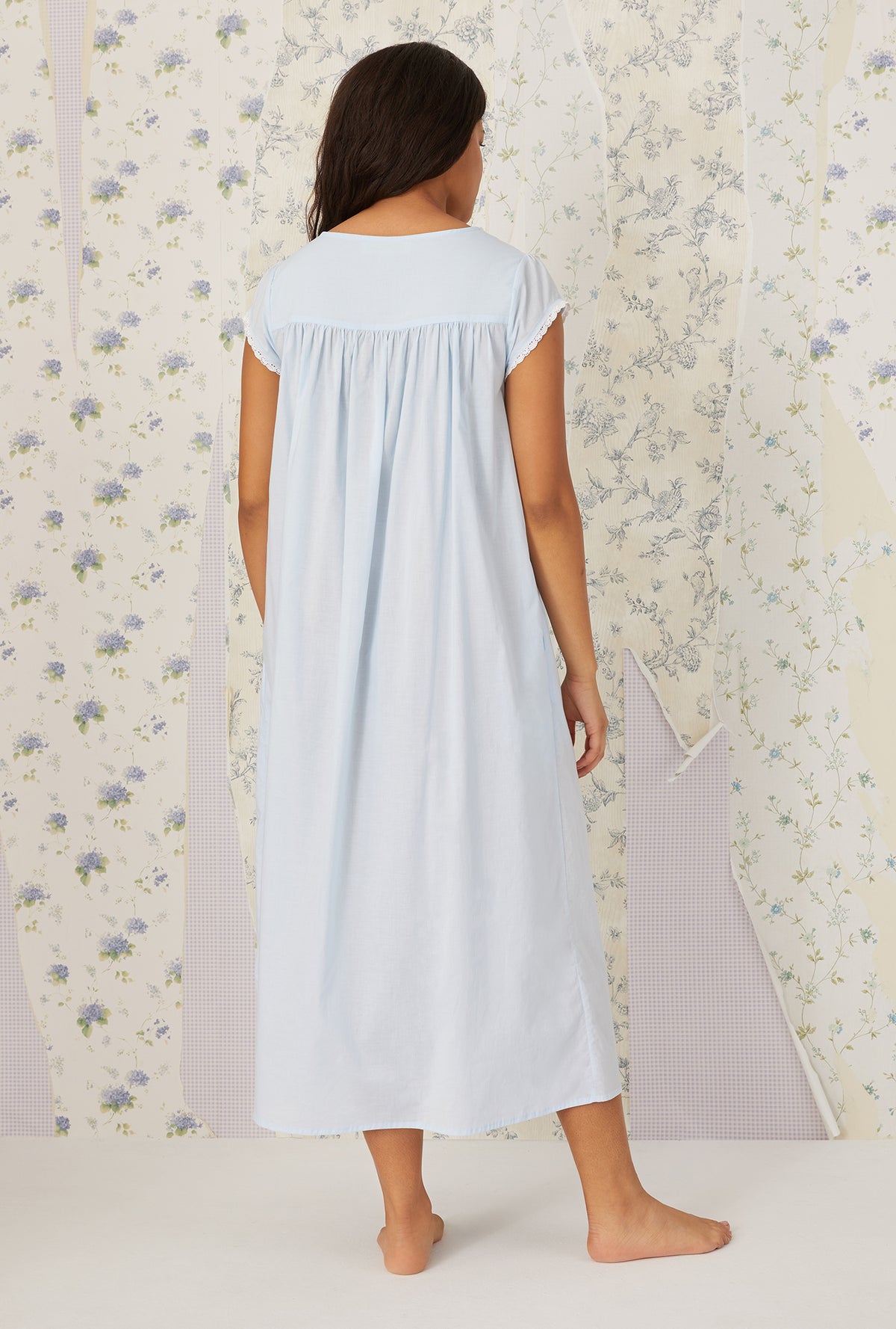 A lady wearing plus size light blue Florentine Lace Cap Sleeve Gown in a  back view pose