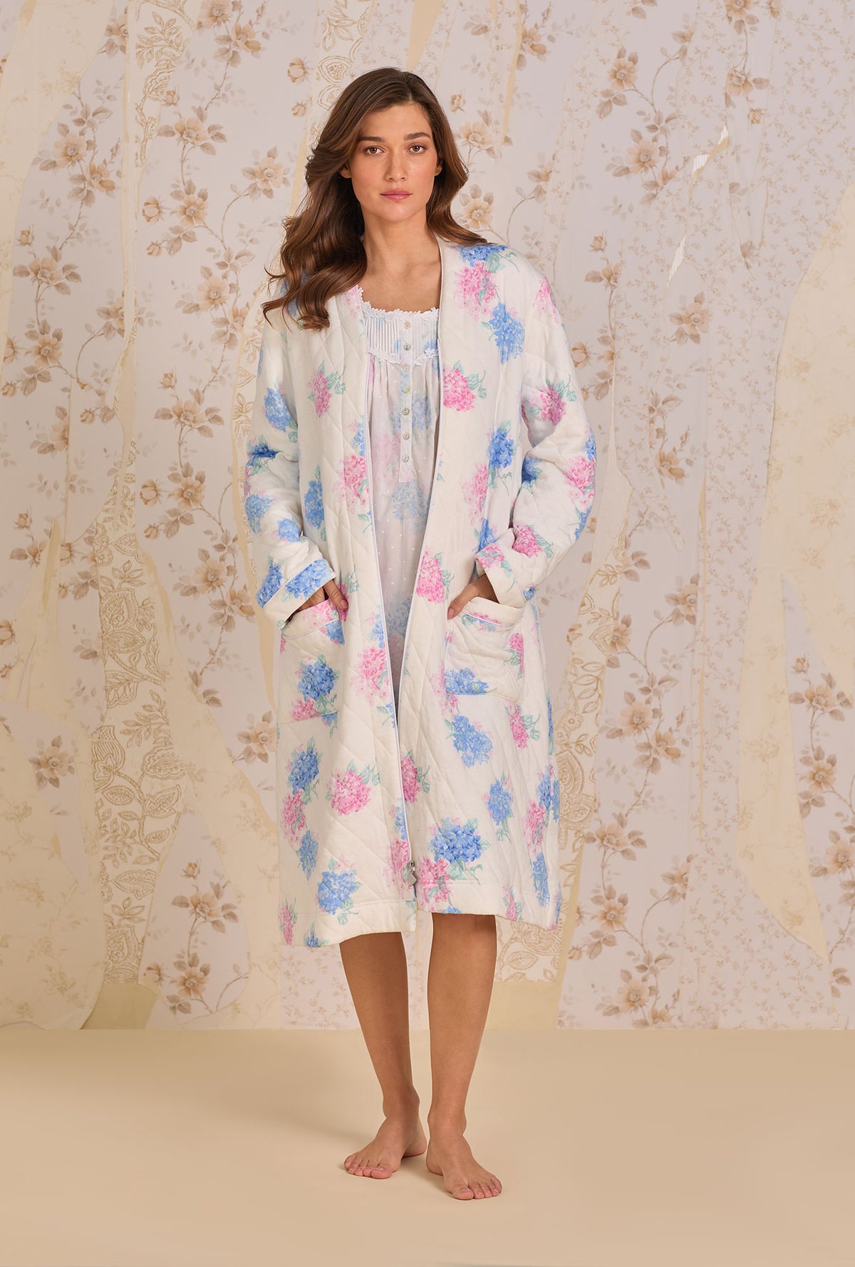 A lady wearing Hydrangea Blossom Dream Diamond Quilt Waltz Zip Robe hands inside the pockets