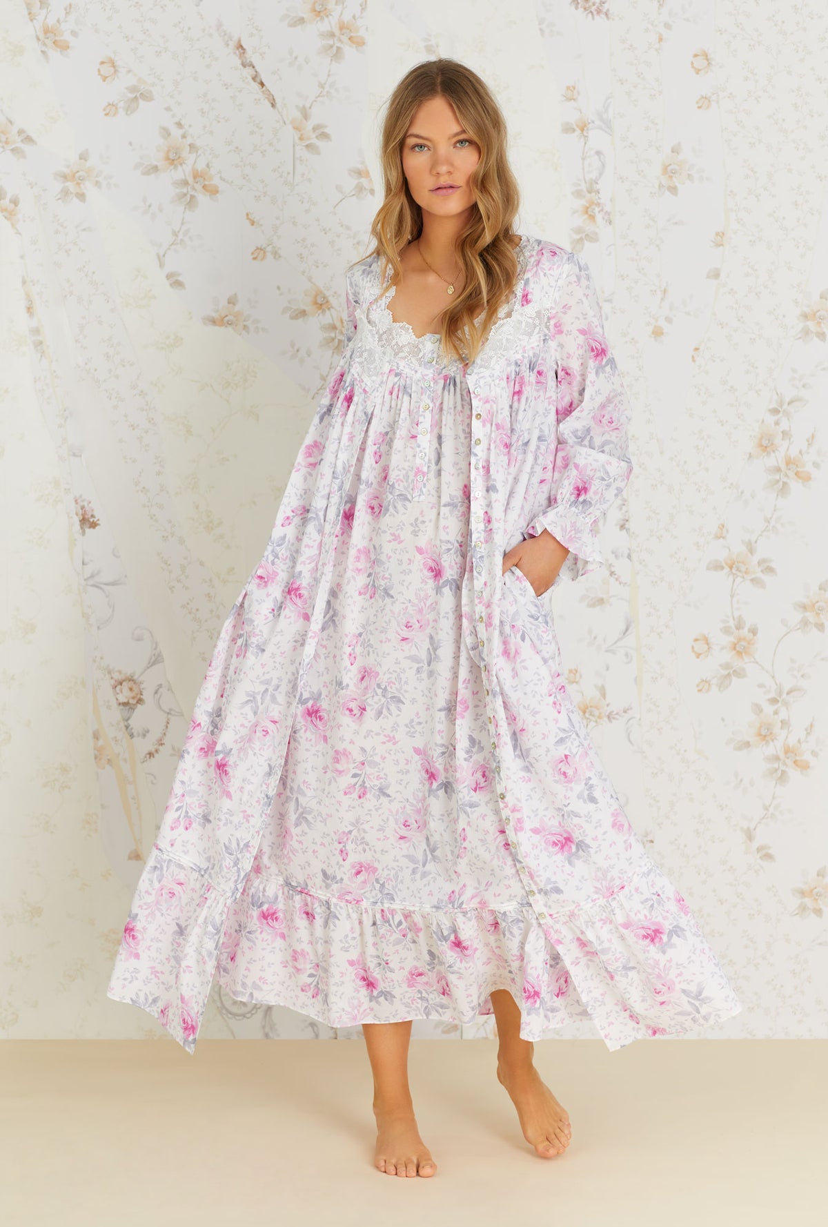 A lady wearing white long sleeve cotton button front robe with mendocino rose print.
