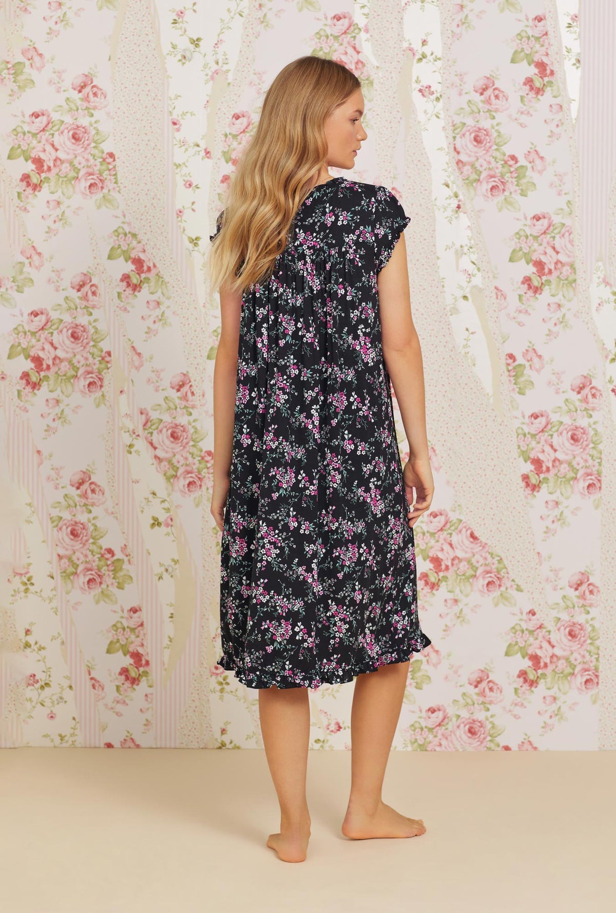 A lady wearing black cap sleeve tencel waltz knit nightgown with valentine floral print.