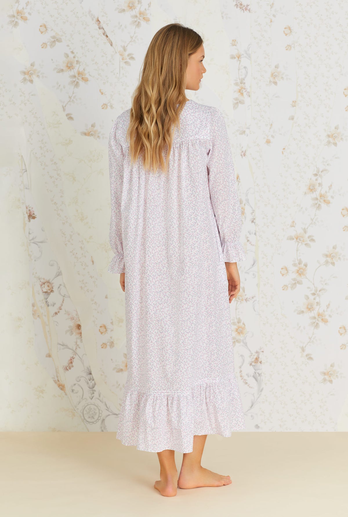 A lady wearing white long sleeve cotton nightgown with baby rosette print.