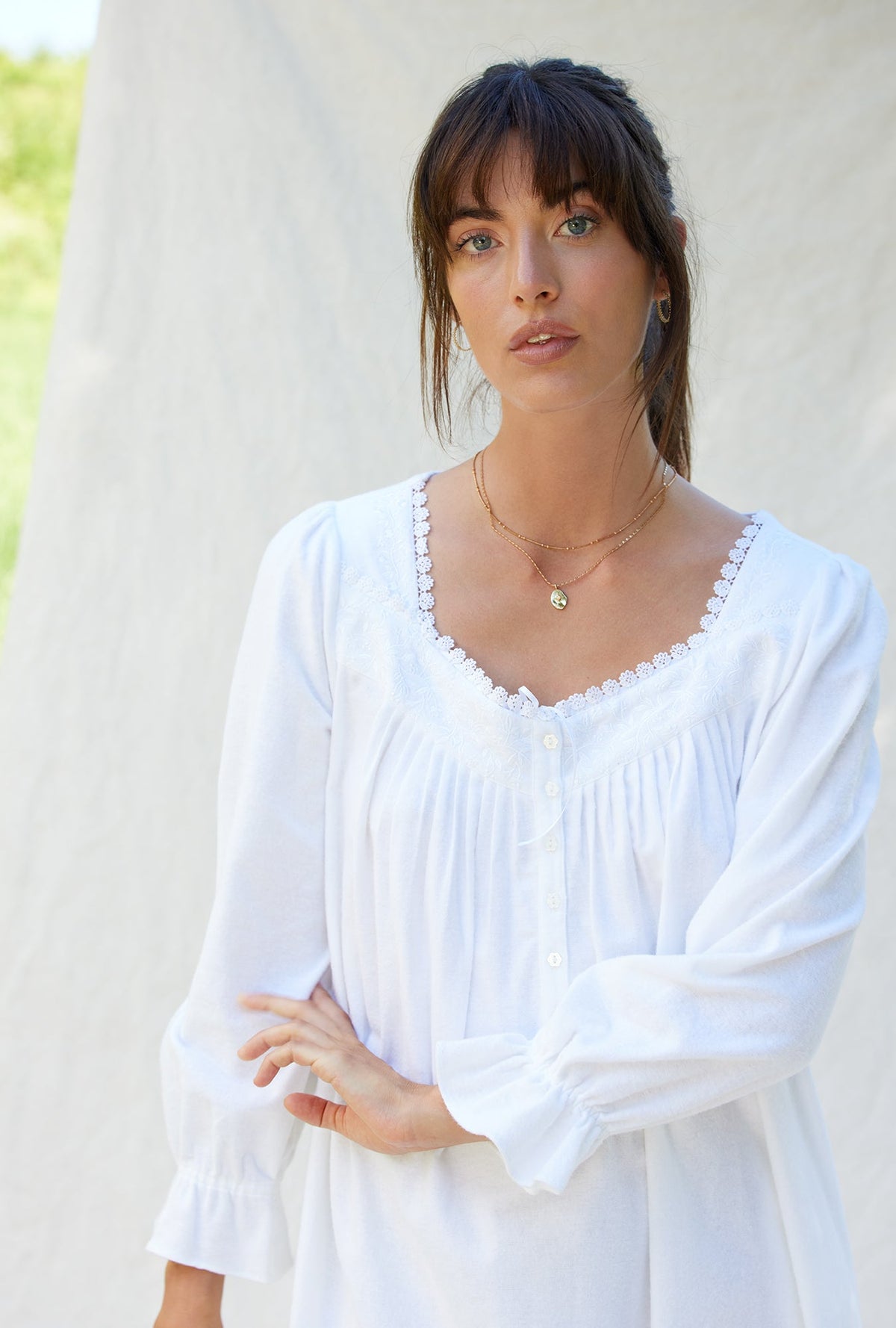 A lady wearing a white long sleeve cotton flannel embroidery nightgown.