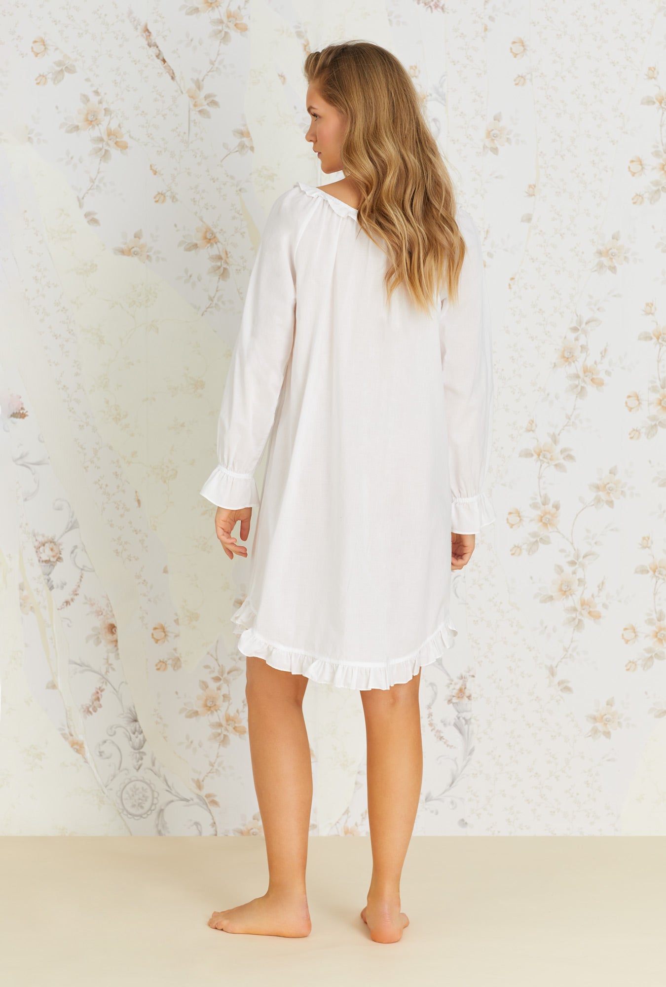A lady wearing white cotton poet nightshirt with divine pattern.
