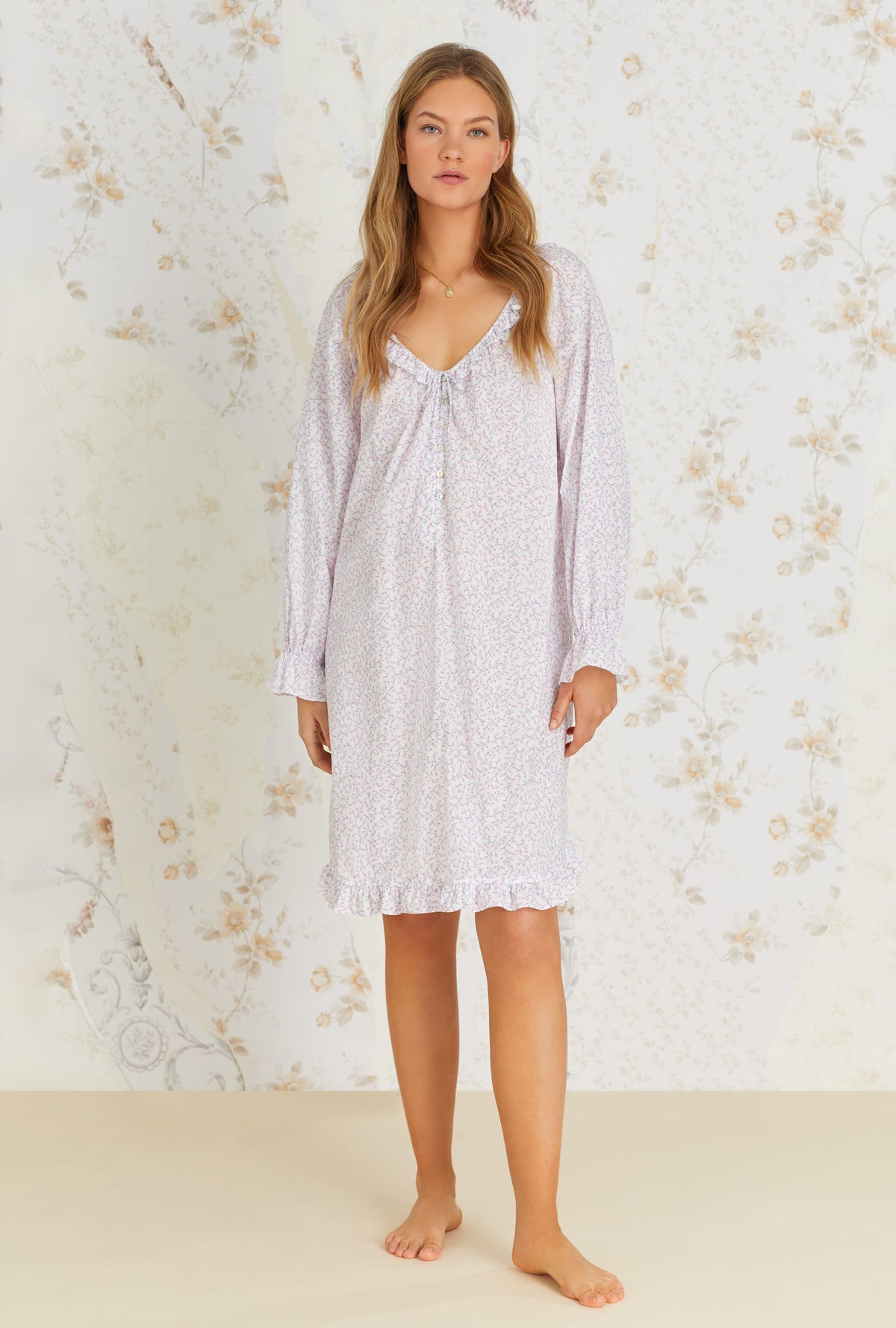 A lady wearing white cotton poet nightshirt with baby rosette print.
