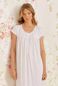 A lady wearing pink cap sleeve waltz knit nightgown with pointelle mini pink bud print.