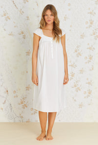 A lady wearing white cap sleeve cotton waltz nightgown with kayla divine pattern.