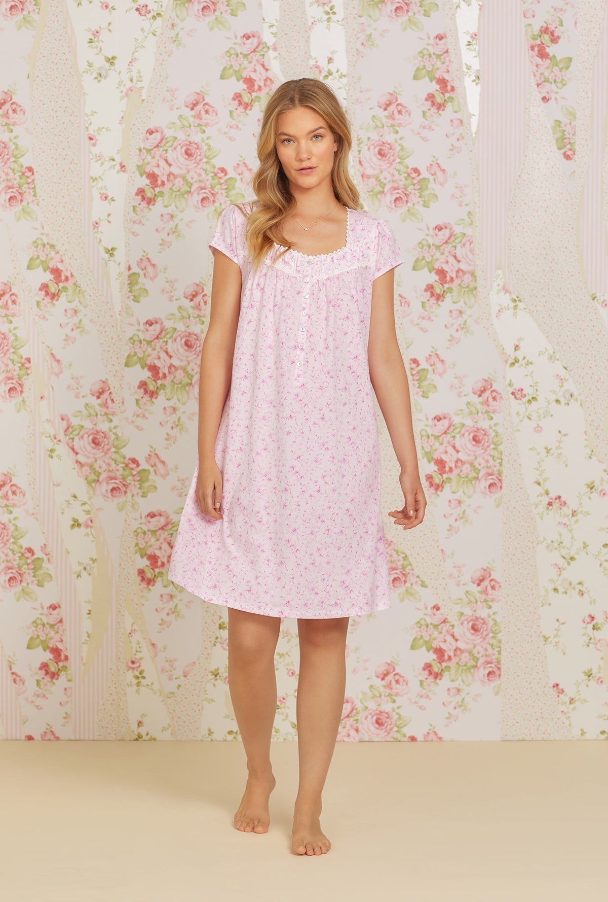 A lady wearing pink cap sleeve short cotton knit nightgown with soft pink floral print.